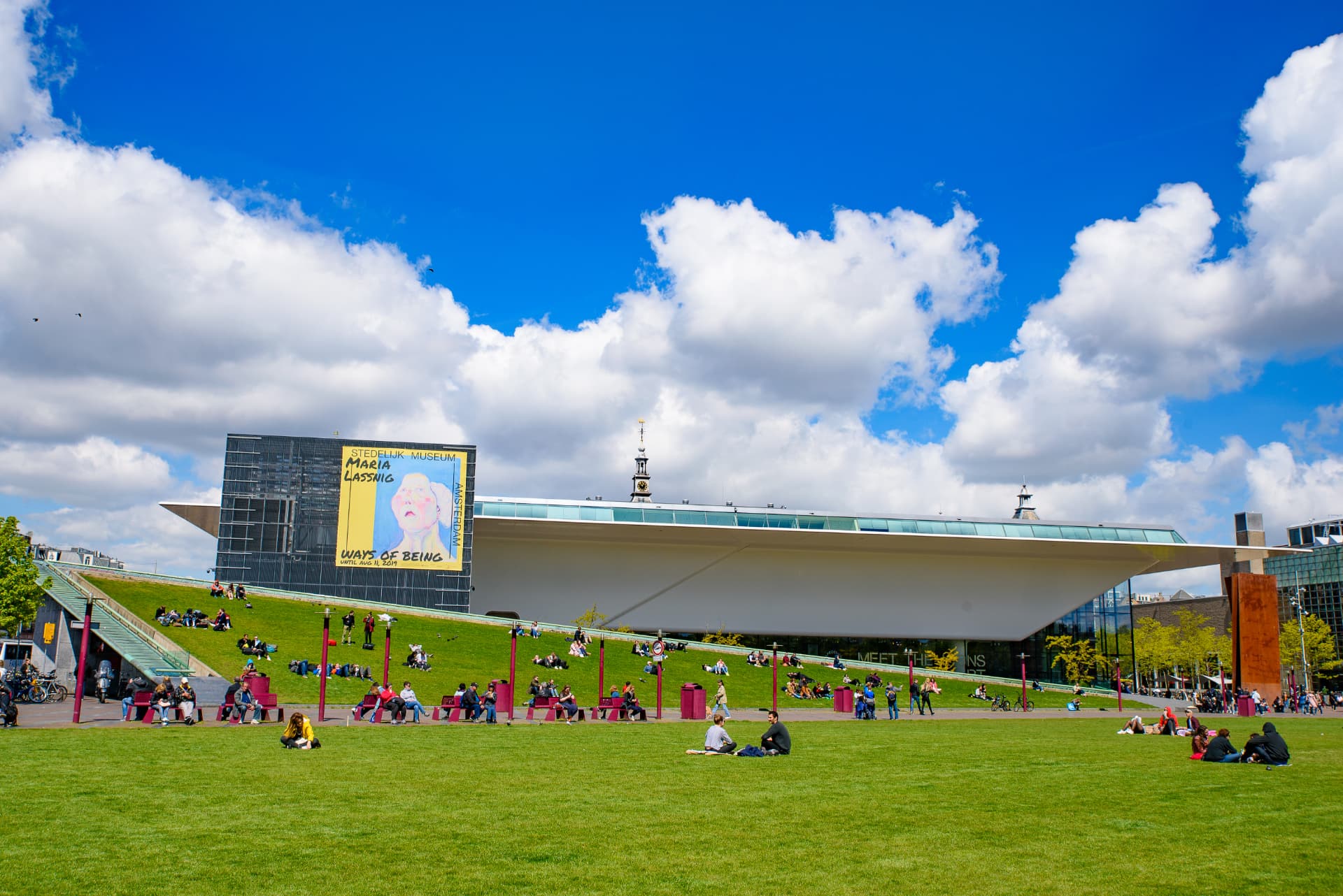 The Stedelijk Museum's white bathtub-shaped extension seen across the Museumplein lawn on a sunny day