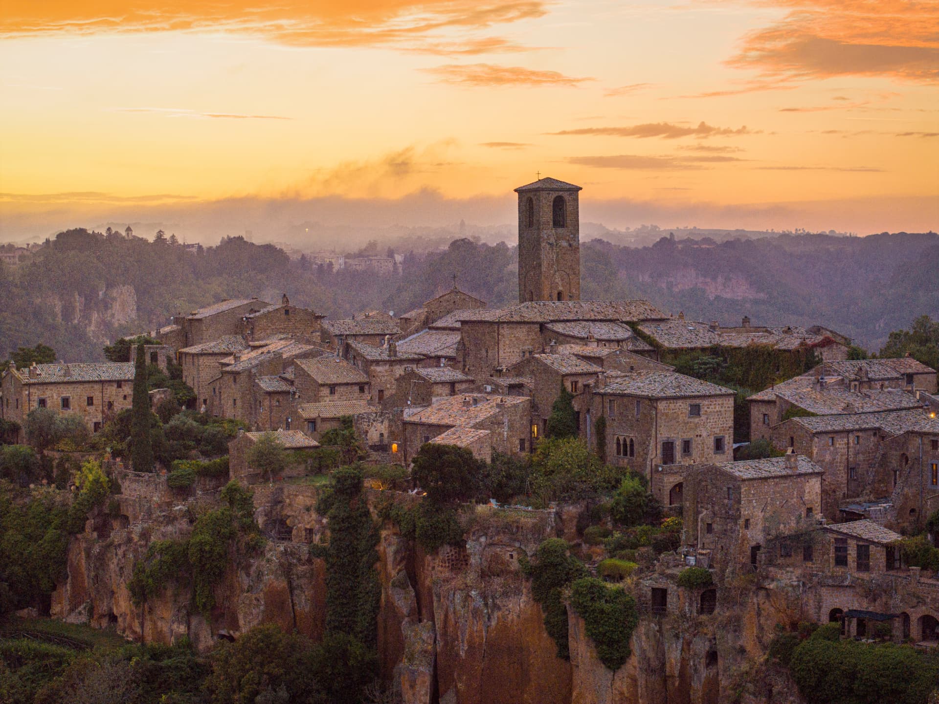 Civita di Bagnoregio's stone houses and bell tower at sunset