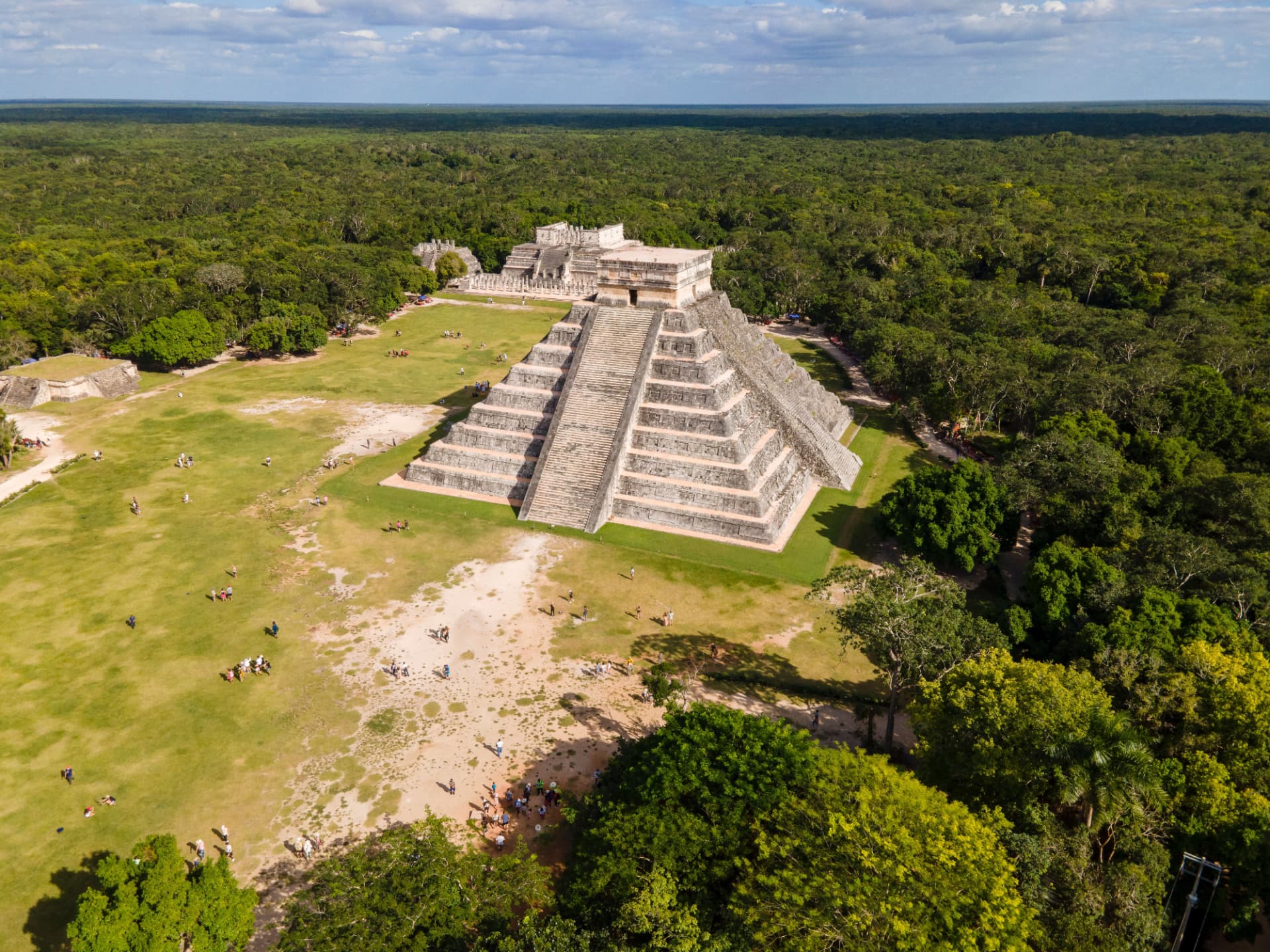 Aerial view of El Castillo rising above the main plaza and dense forest at Chichén Itzá