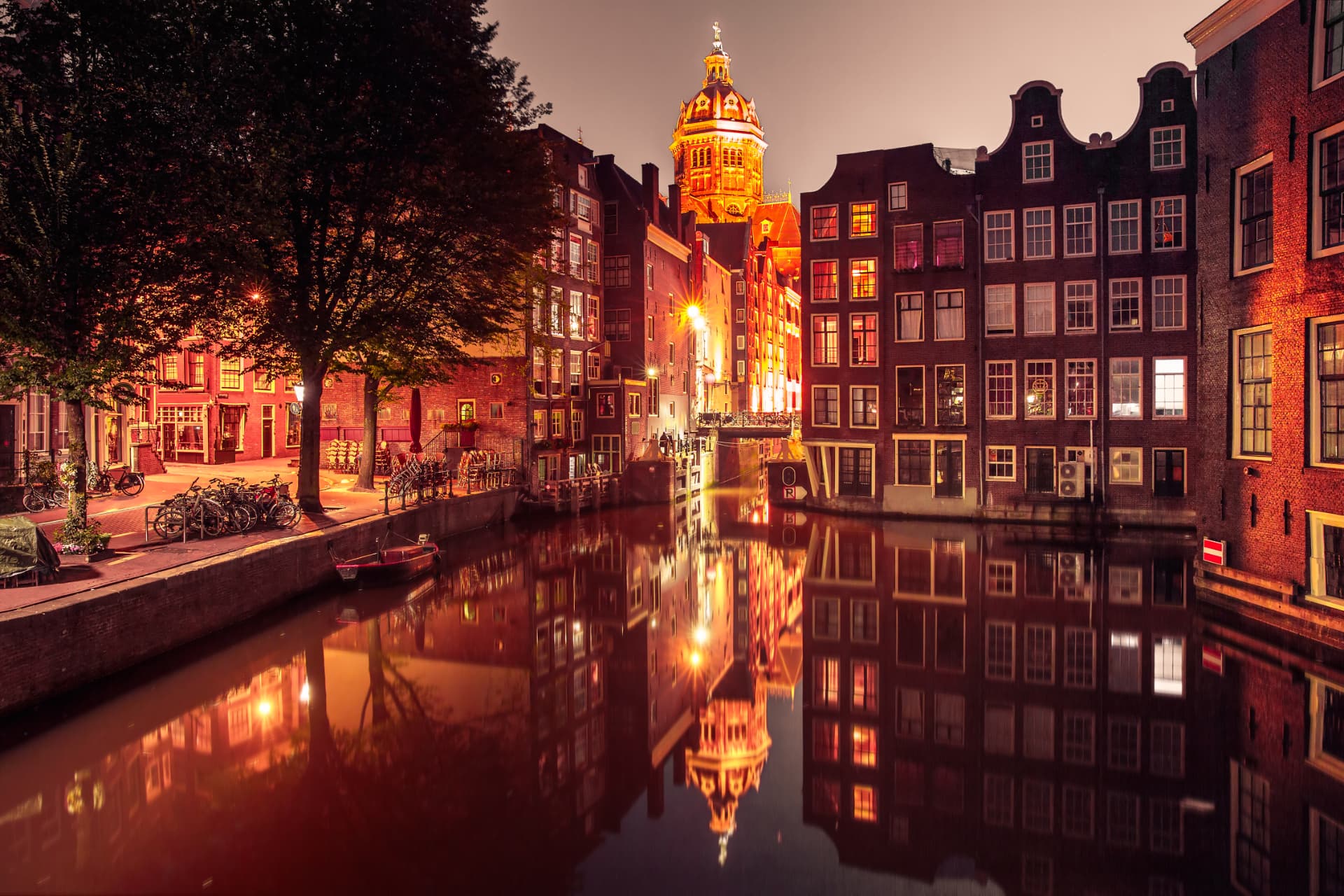 St Nicholas Basilica dome and canal houses reflected in a De Wallen canal at night