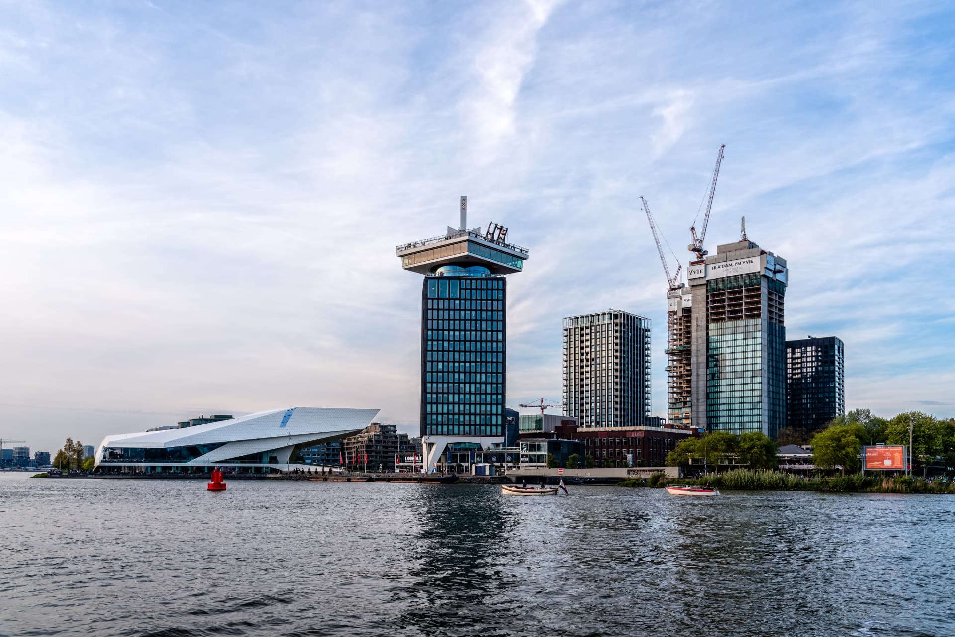 The A'DAM Tower and Eye Filmmuseum seen across the IJ river in Amsterdam, with boats on the water