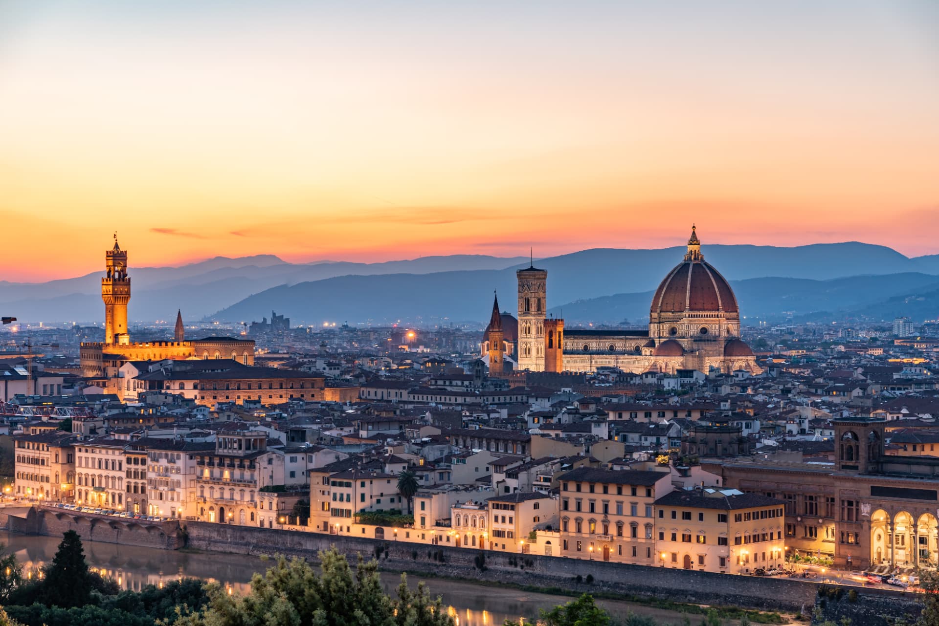 Florence at sunset: the Duomo, Giotto's bell tower and Palazzo Vecchio above the rooftops and the Arno