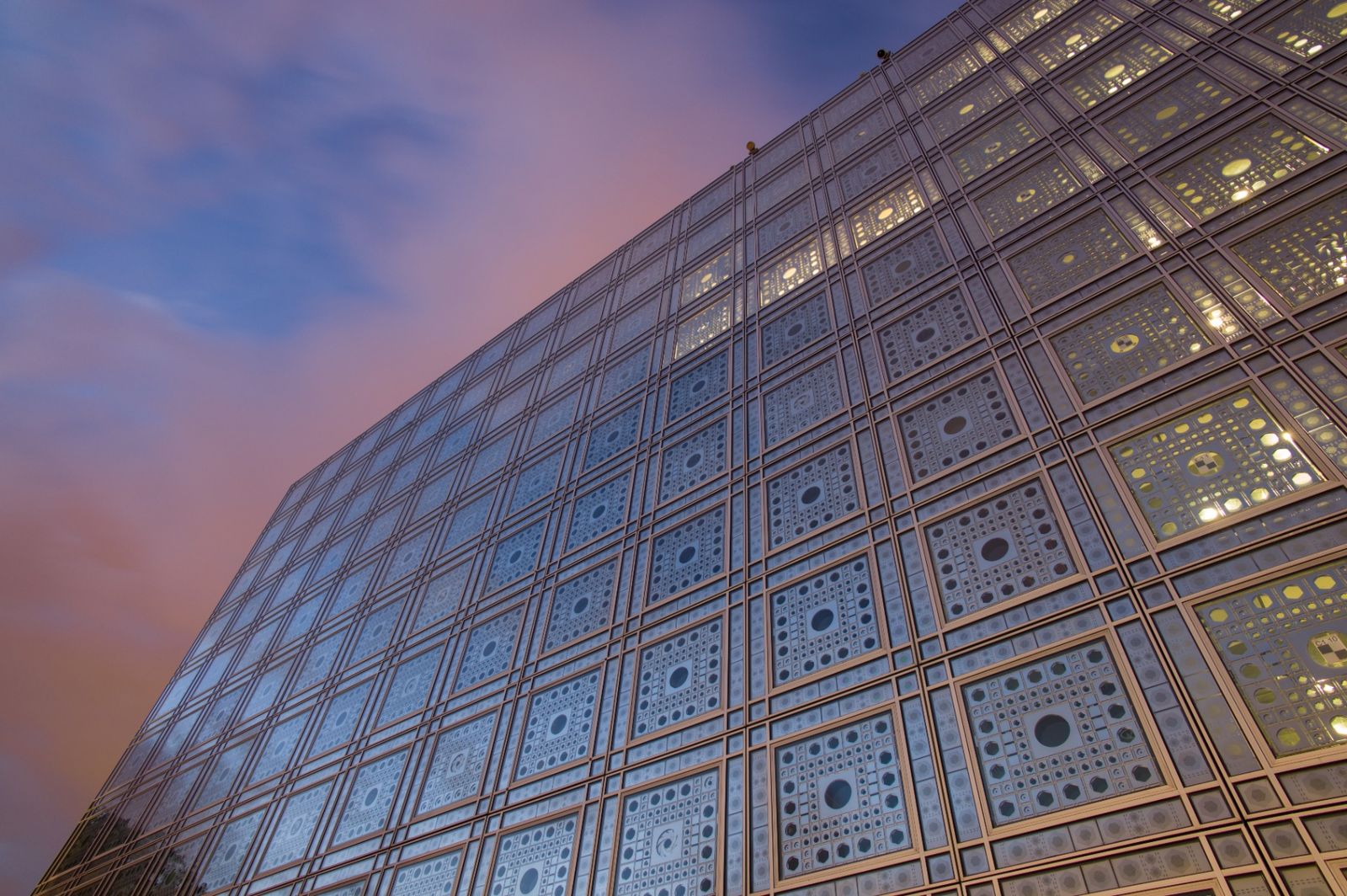 The striking geometric facade of Institut du Monde Arabe in Paris at dusk