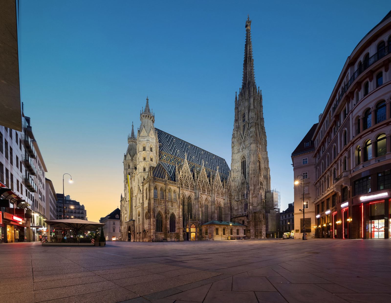 St Stephen's Cathedral on Stephansplatz at twilight with its illuminated Gothic facade, patterned tile roof and tall south spire