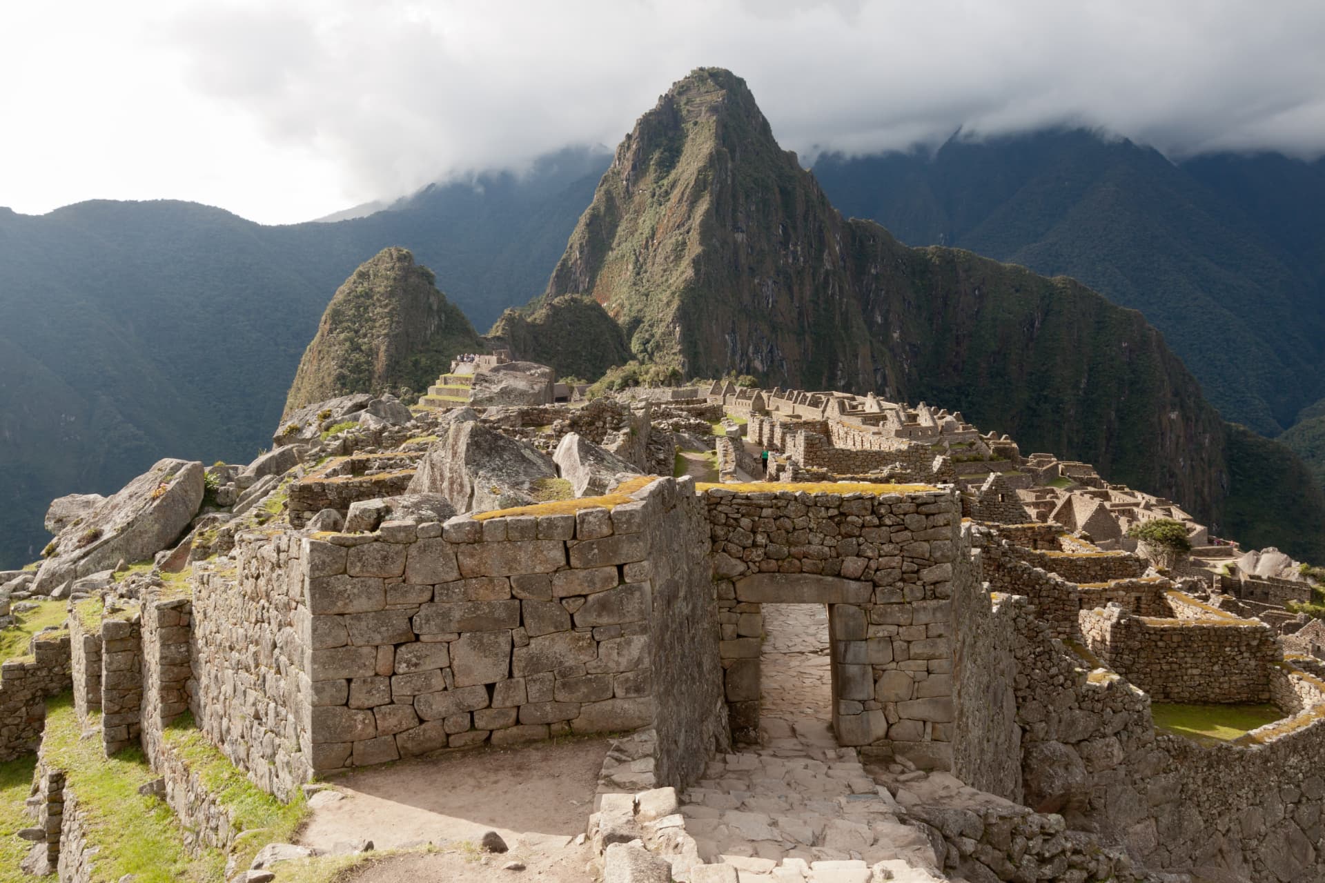 Stone gate and ancient walls inside Machu Picchu with Huayna Picchu mountain in the background