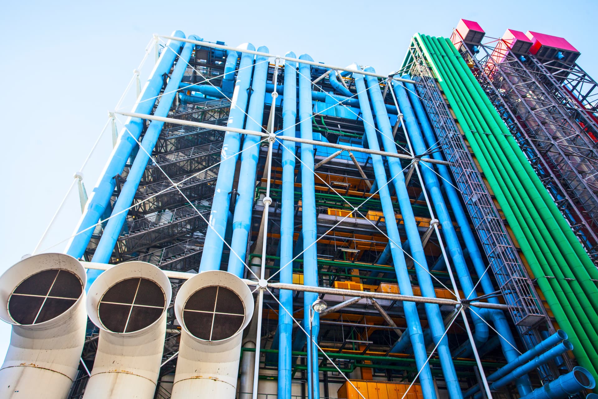 Looking up at the Centre Pompidou's blue ventilation ducts, green water pipes and white structural bracing
