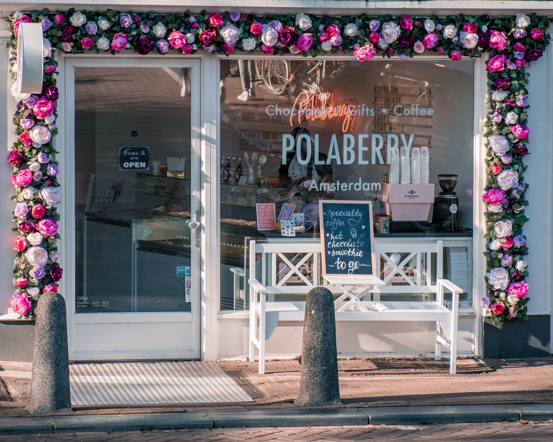 A flower-framed chocolate and coffee shopfront in the 9 Streets district of Amsterdam