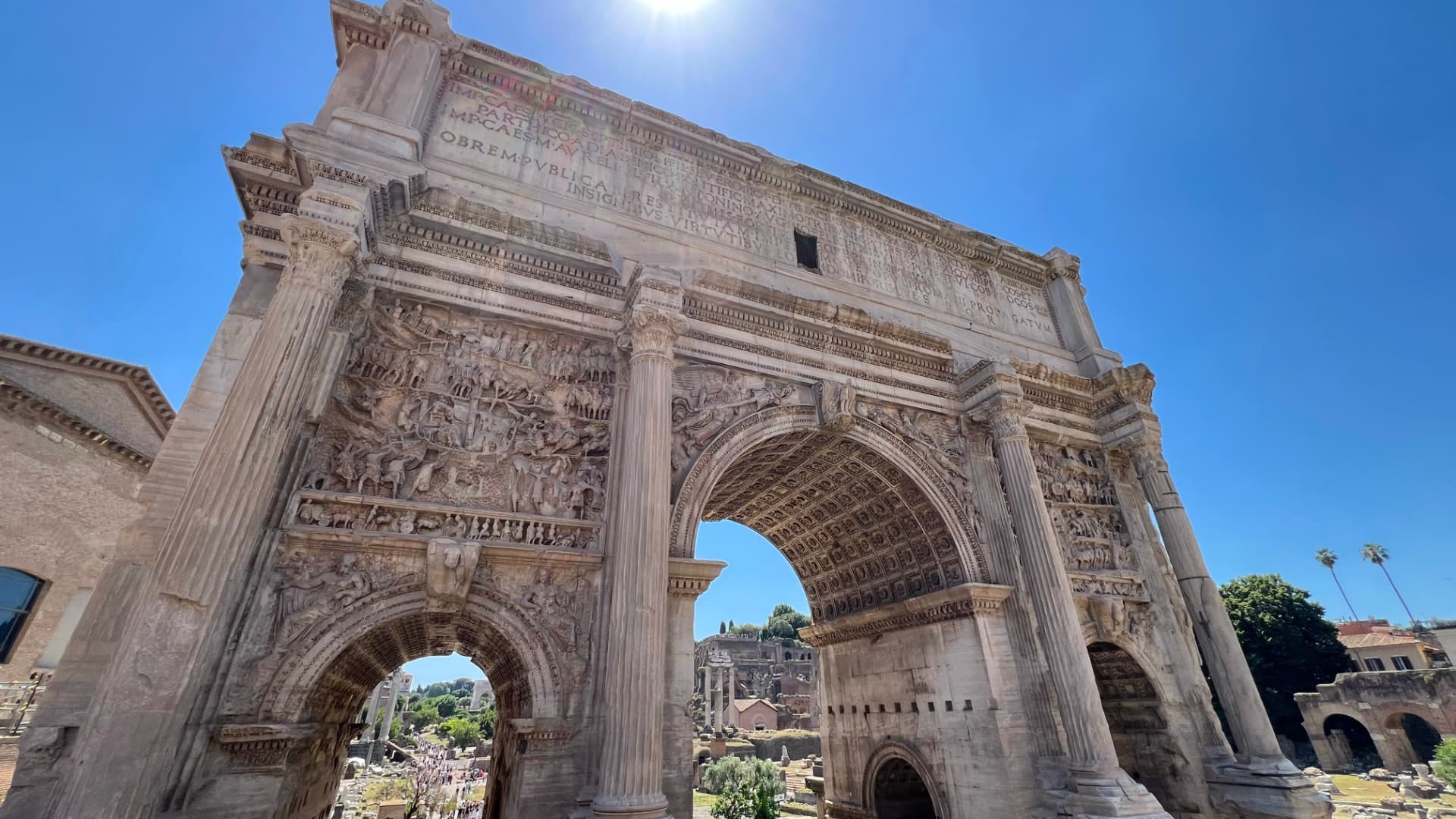 Arch of Septimius Severus with its inscription and large relief panels under a clear sky