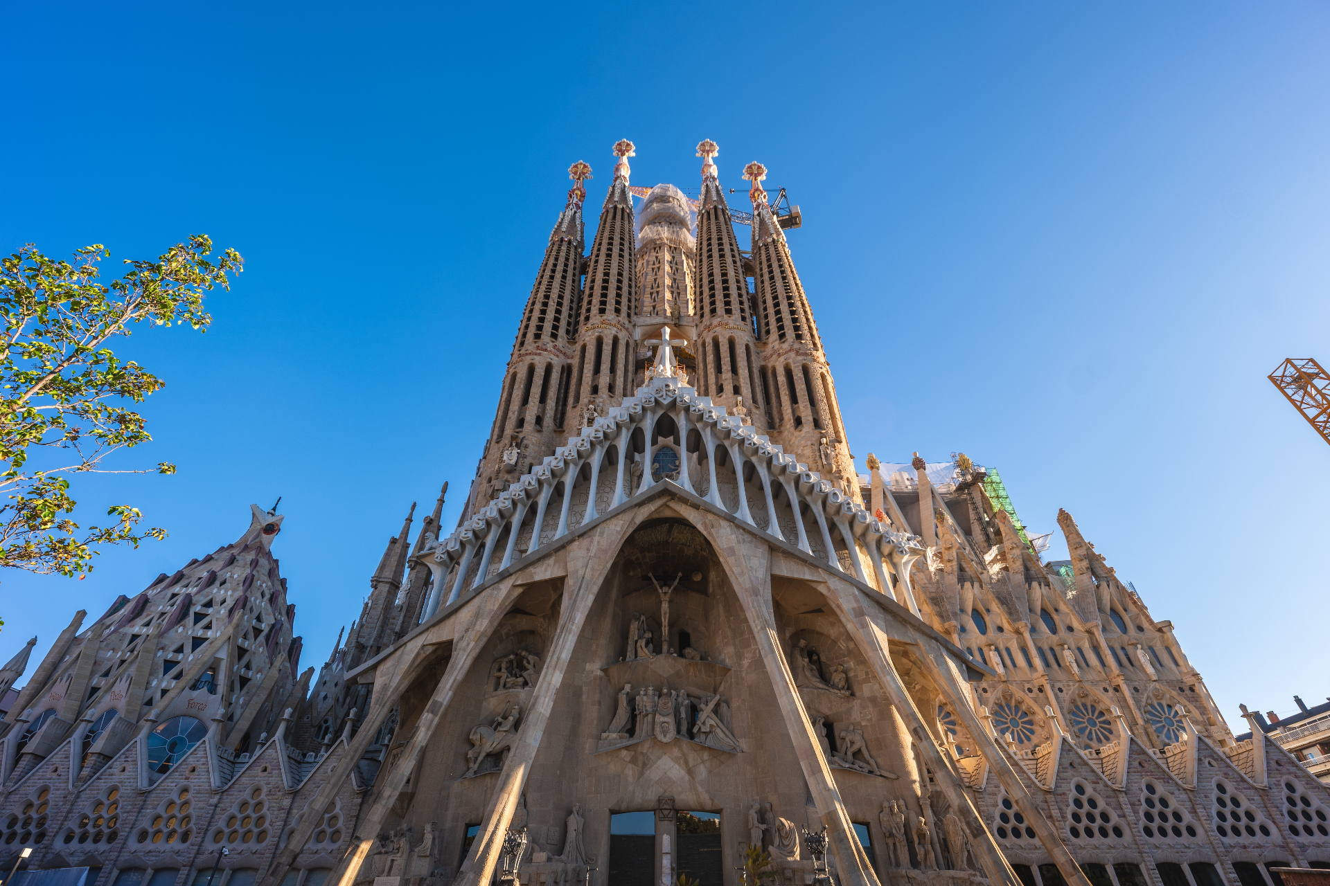 Sagrada Família basilica in Barcelona with intricate Gothic and Art Nouveau facades against a clear blue sky