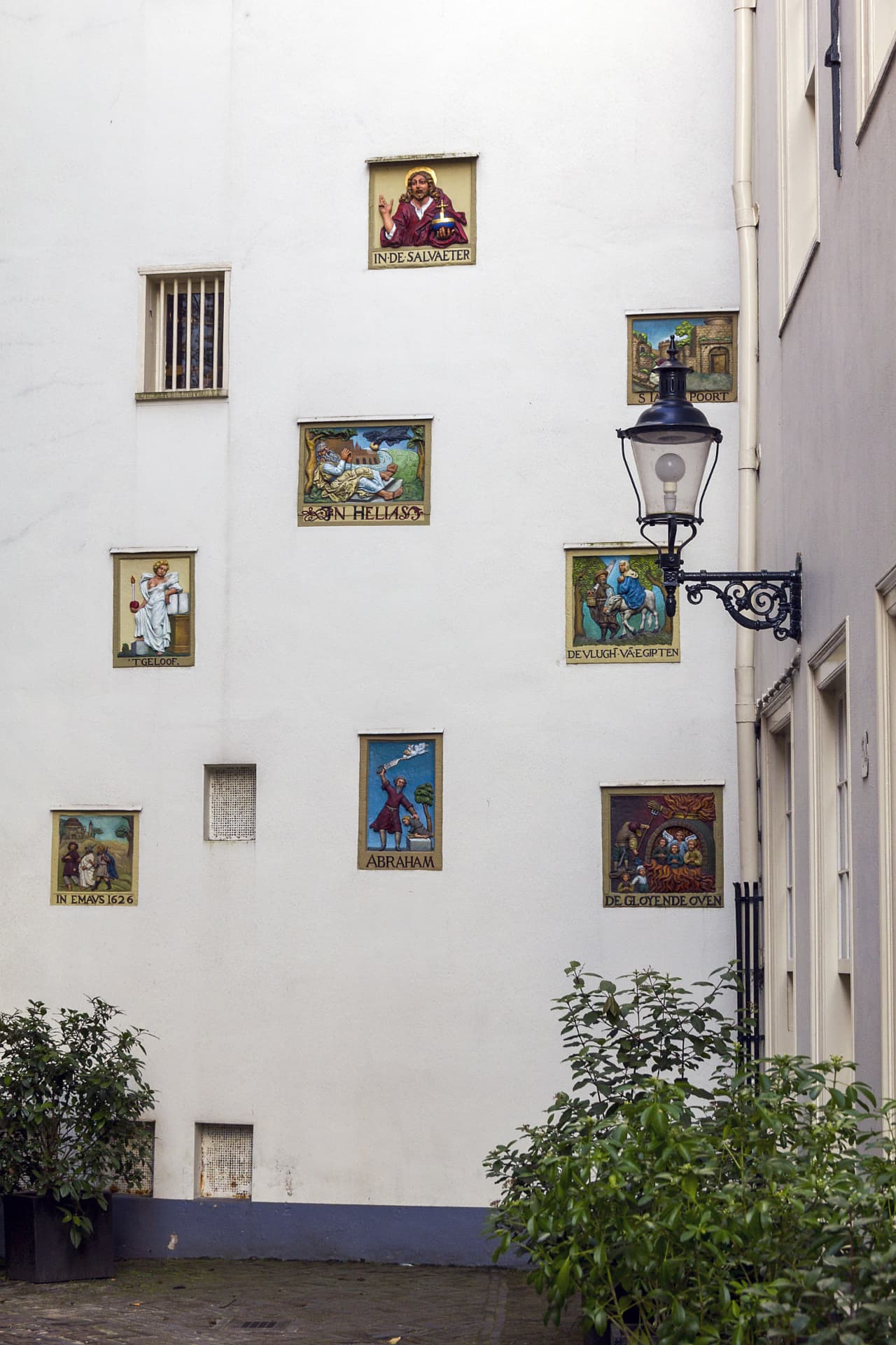 Historic gable stones with biblical scenes on a wall at the Begijnhof in Amsterdam