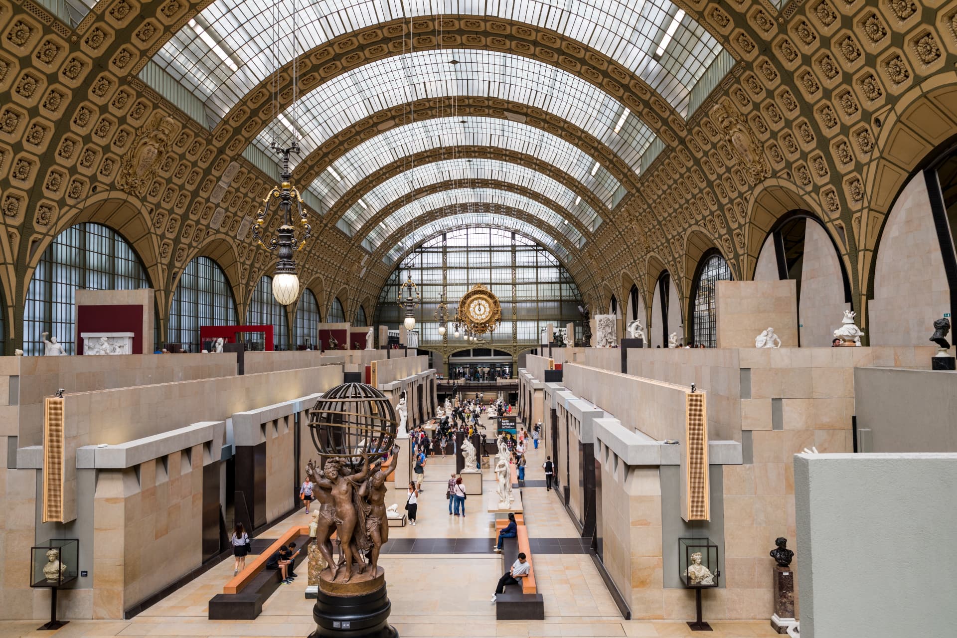 The barrel-vaulted great hall of the Musée d'Orsay with sculpture displays beneath the gilded clock