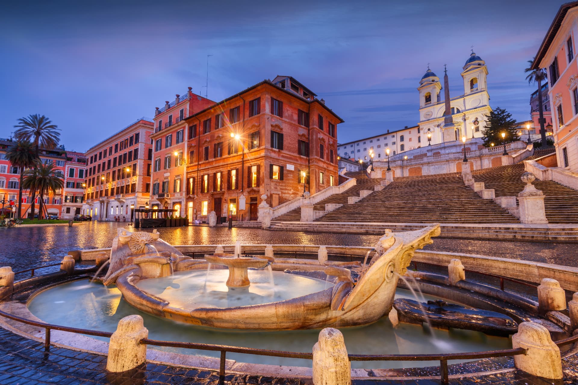 Barcaccia fountain at twilight with the Spanish Steps rising behind it