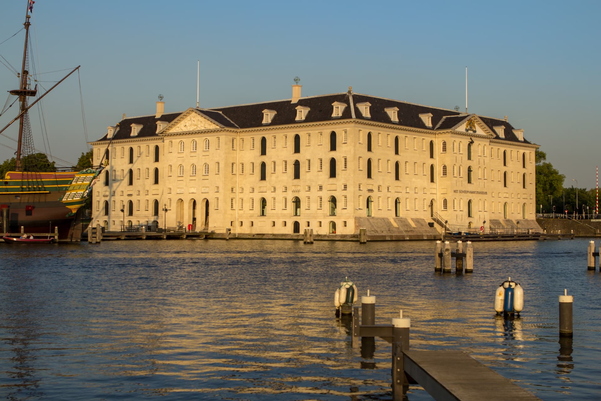 The sandstone facade of the National Maritime Museum in Amsterdam glowing in golden evening light