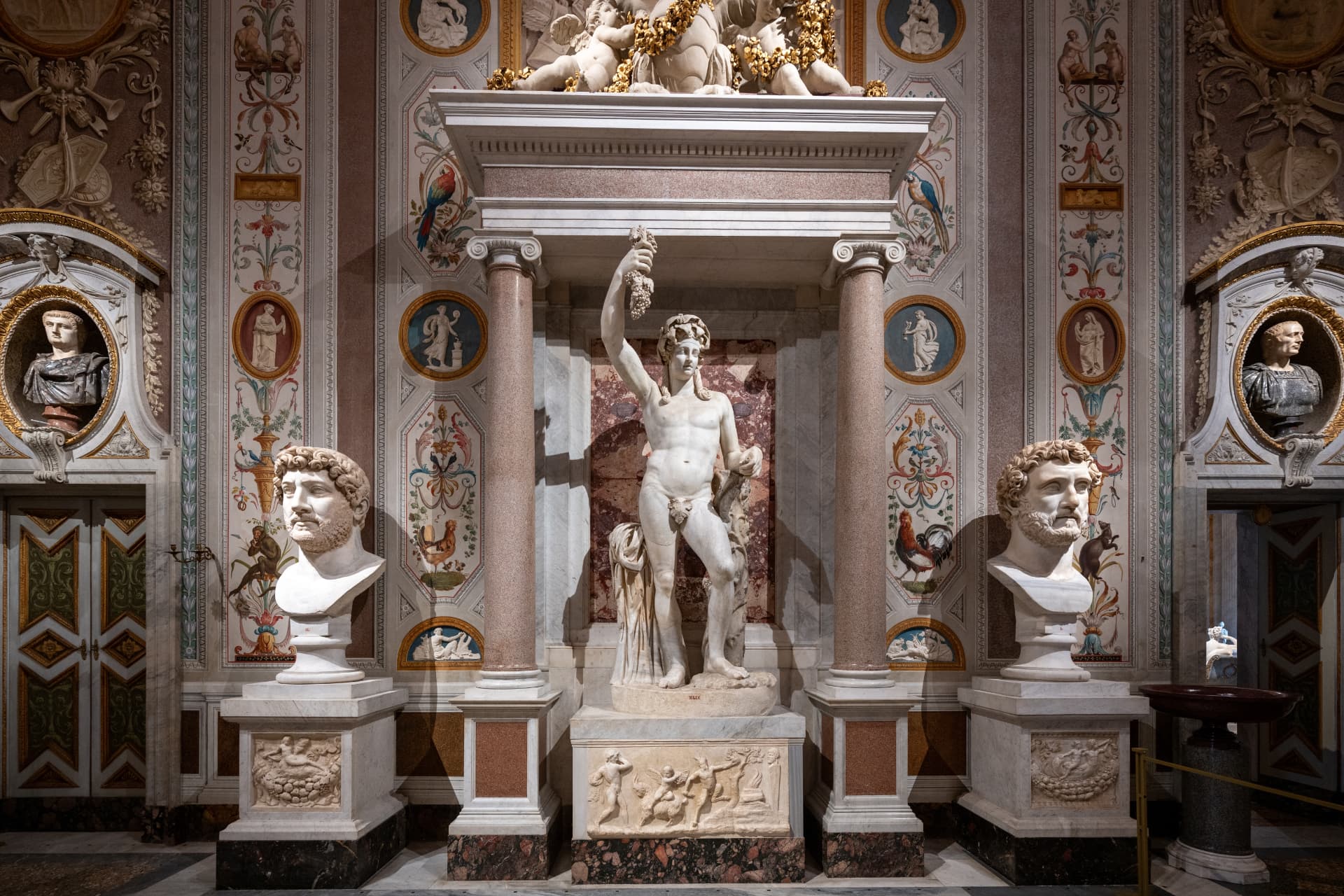 Ancient sculptures displayed in a richly decorated Borghese Gallery room