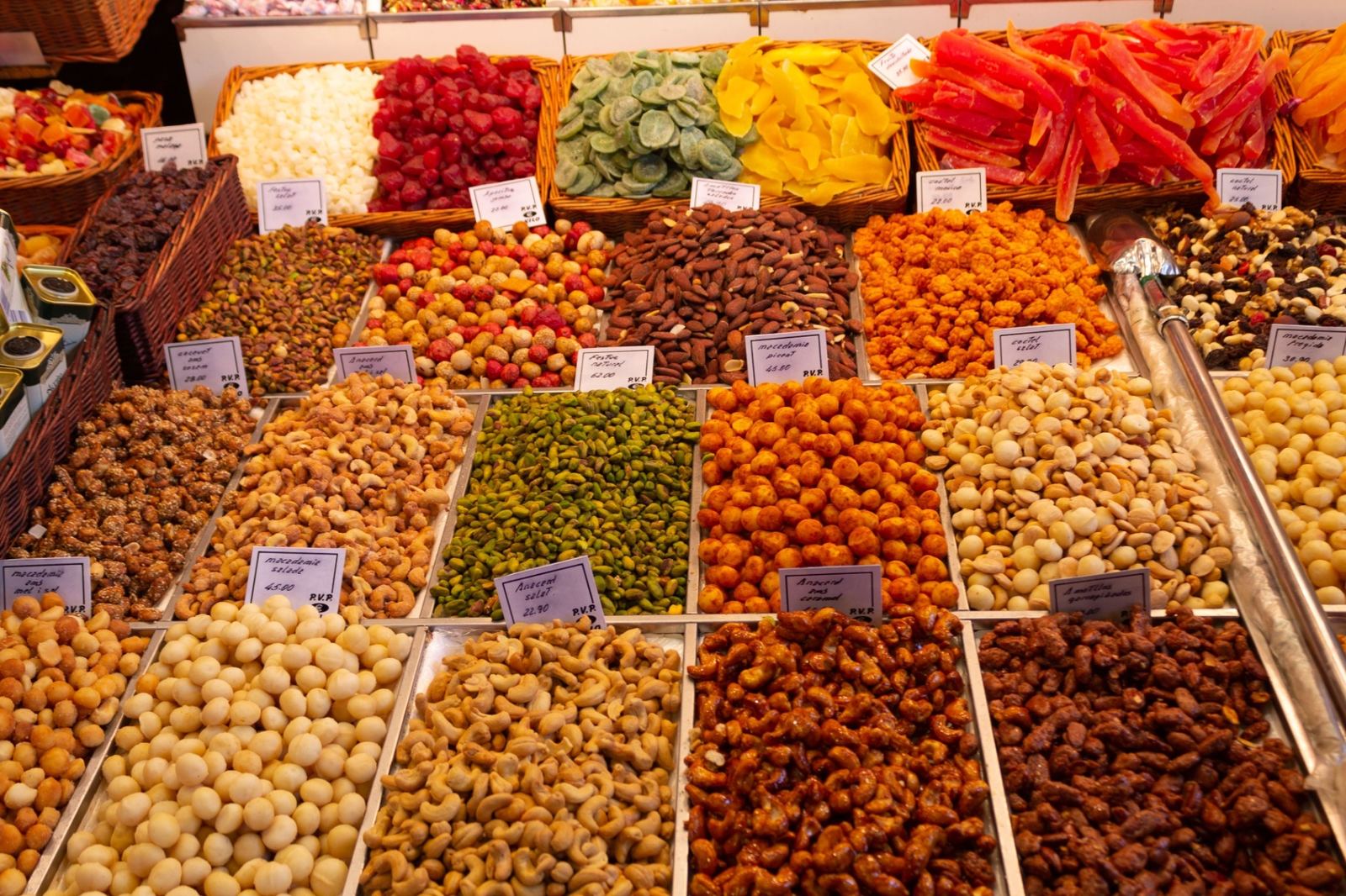 Colourful dried fruits, nuts and candied sweets displayed in wicker baskets at La Boqueria market in Barcelona