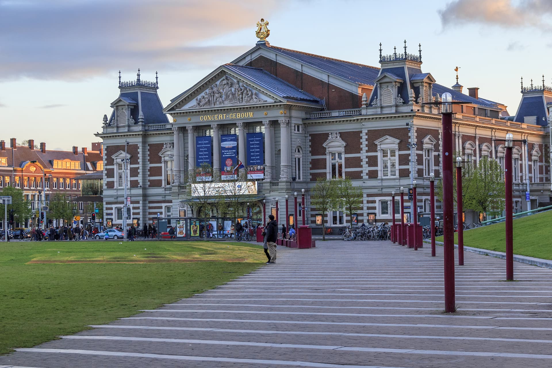 The Concertgebouw in warm evening light with people arriving for a concert