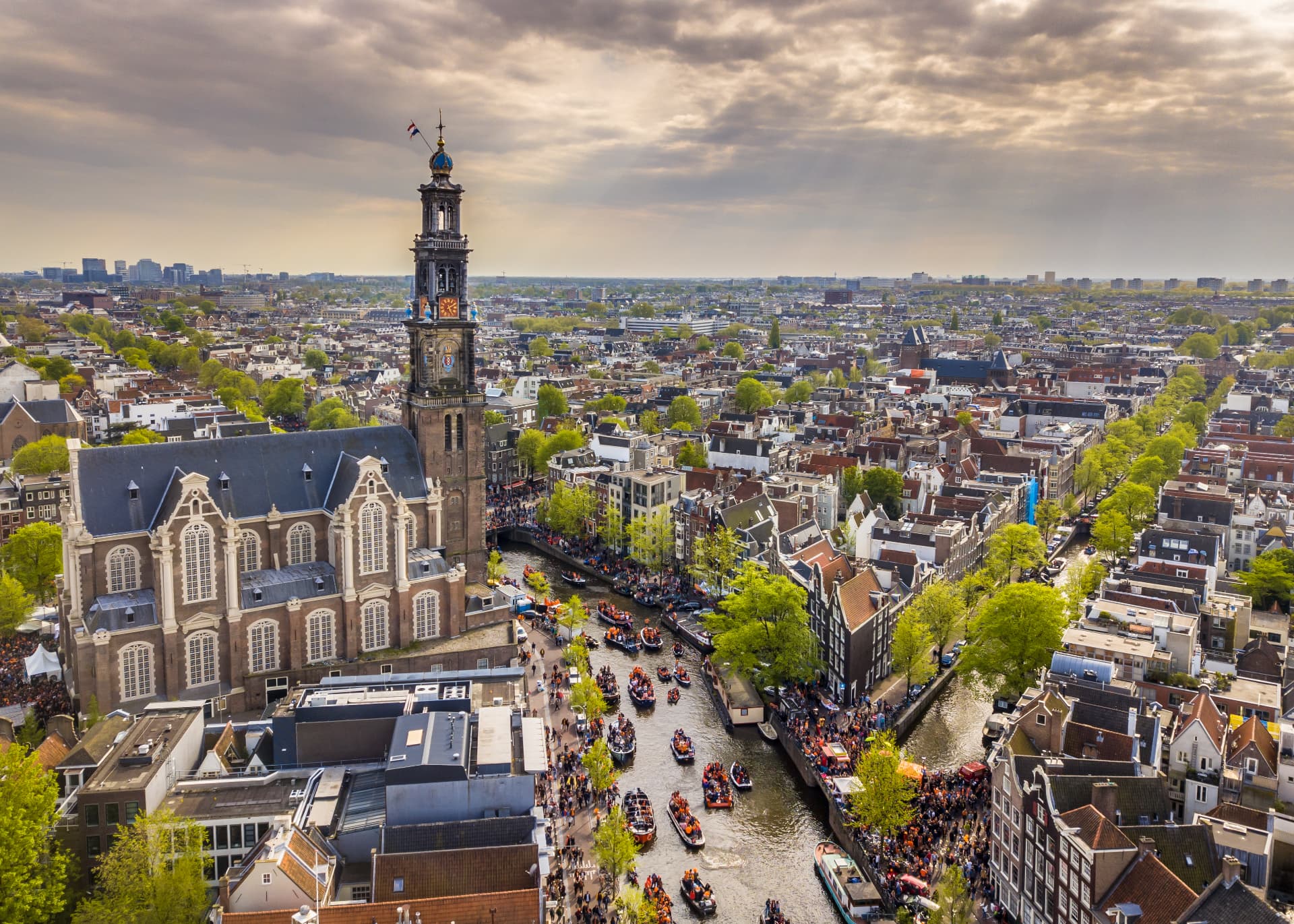 Aerial view of the Westertoren rising over the Prinsengracht canal on King's Day in Amsterdam