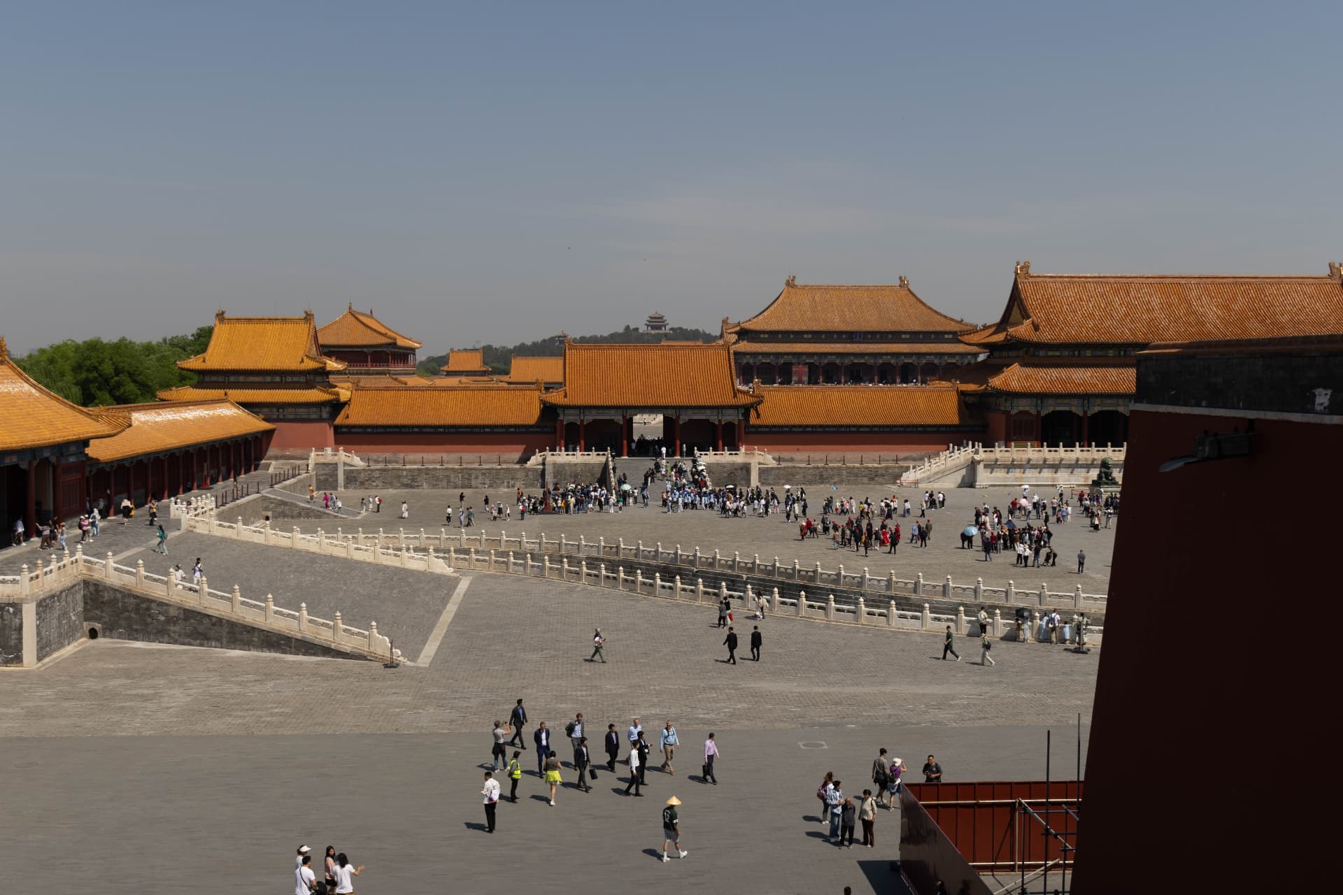 Broad Forbidden City courtyard with marble terraces and visitors among palace halls