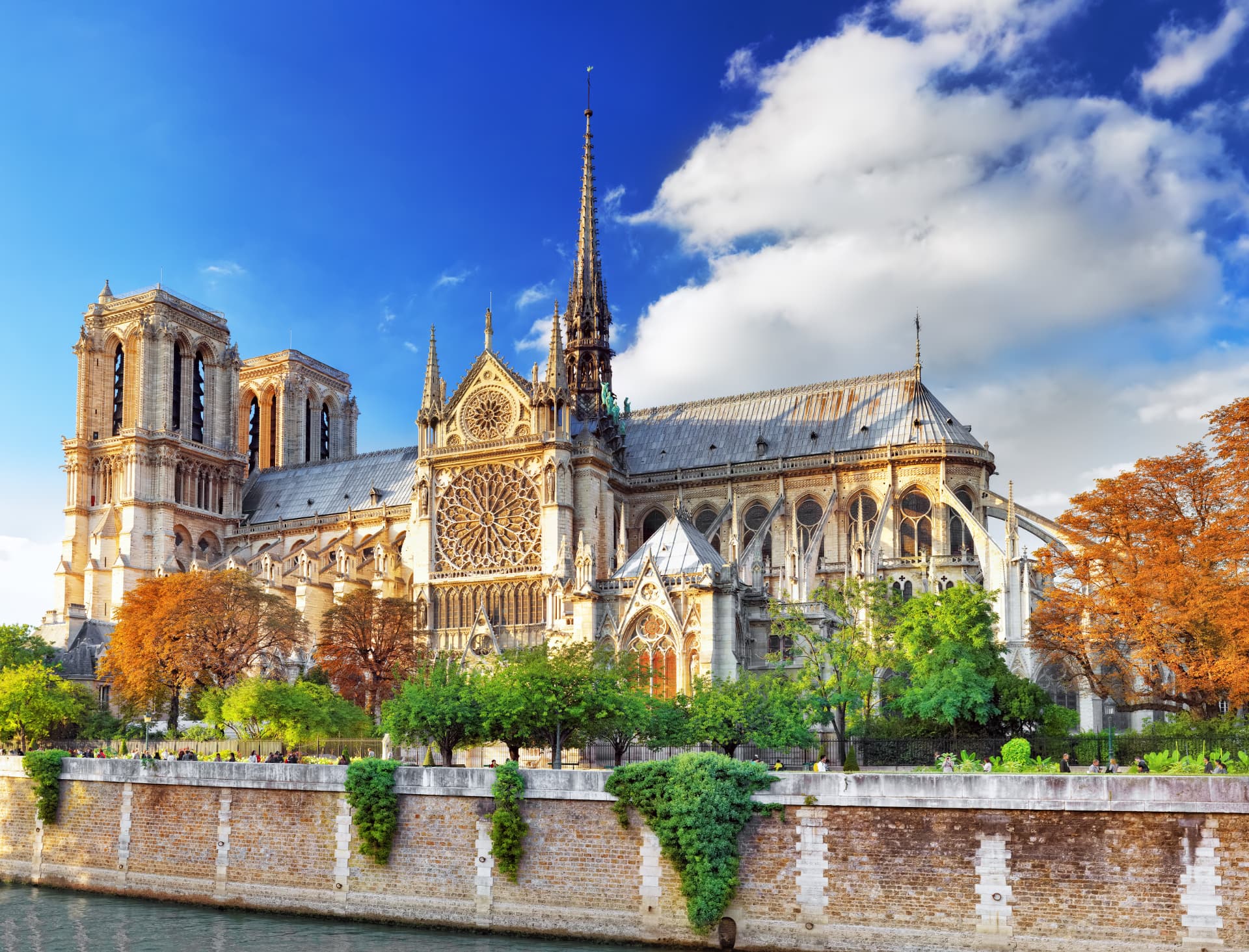Notre-Dame Cathedral seen from the Seine with its spire, flying buttresses and south rose window