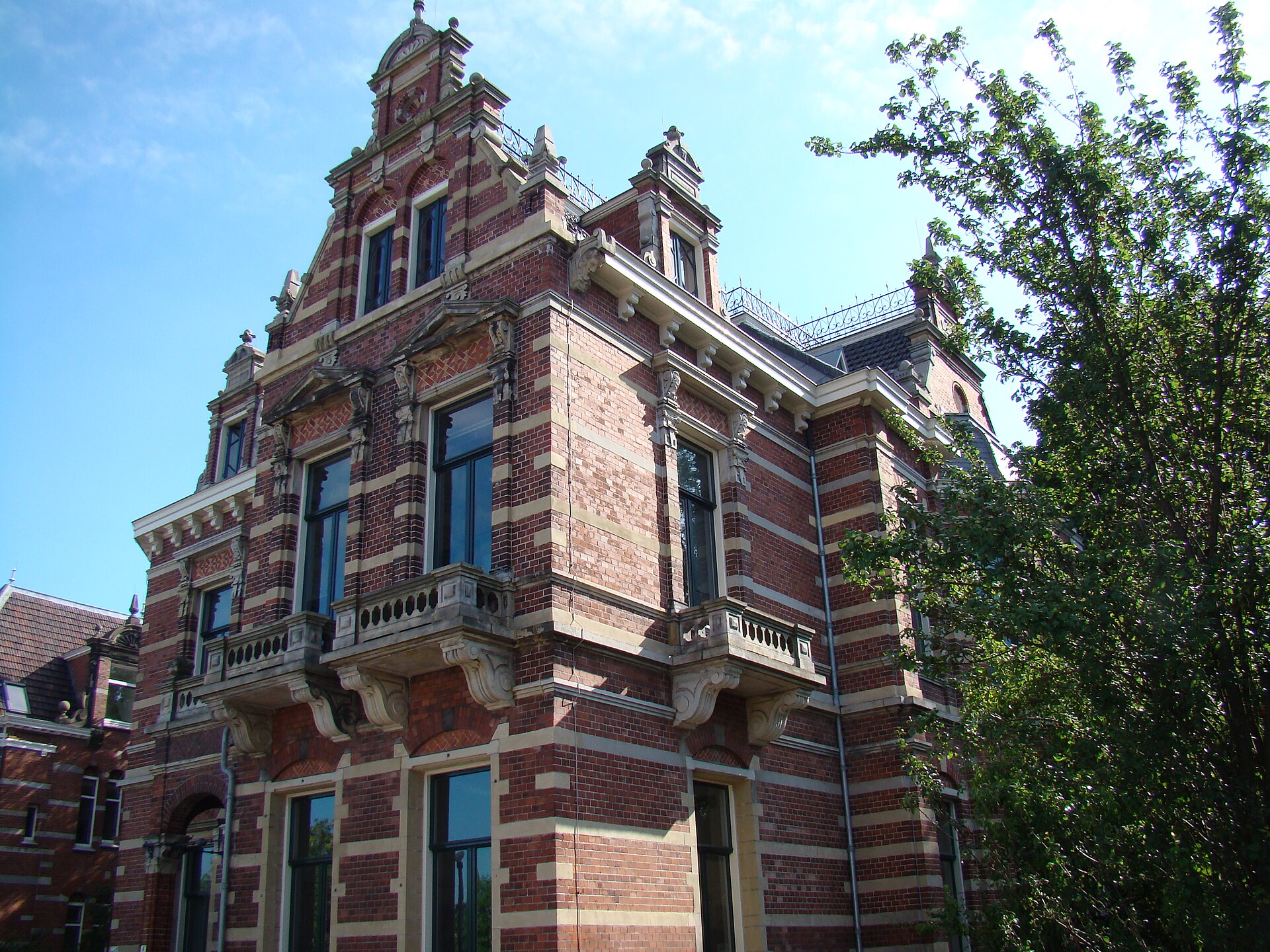 Ornate 19th-century red-brick villa with stone balconies and a stepped gable on the Haarlemmerweg by Westerpark, Amsterdam