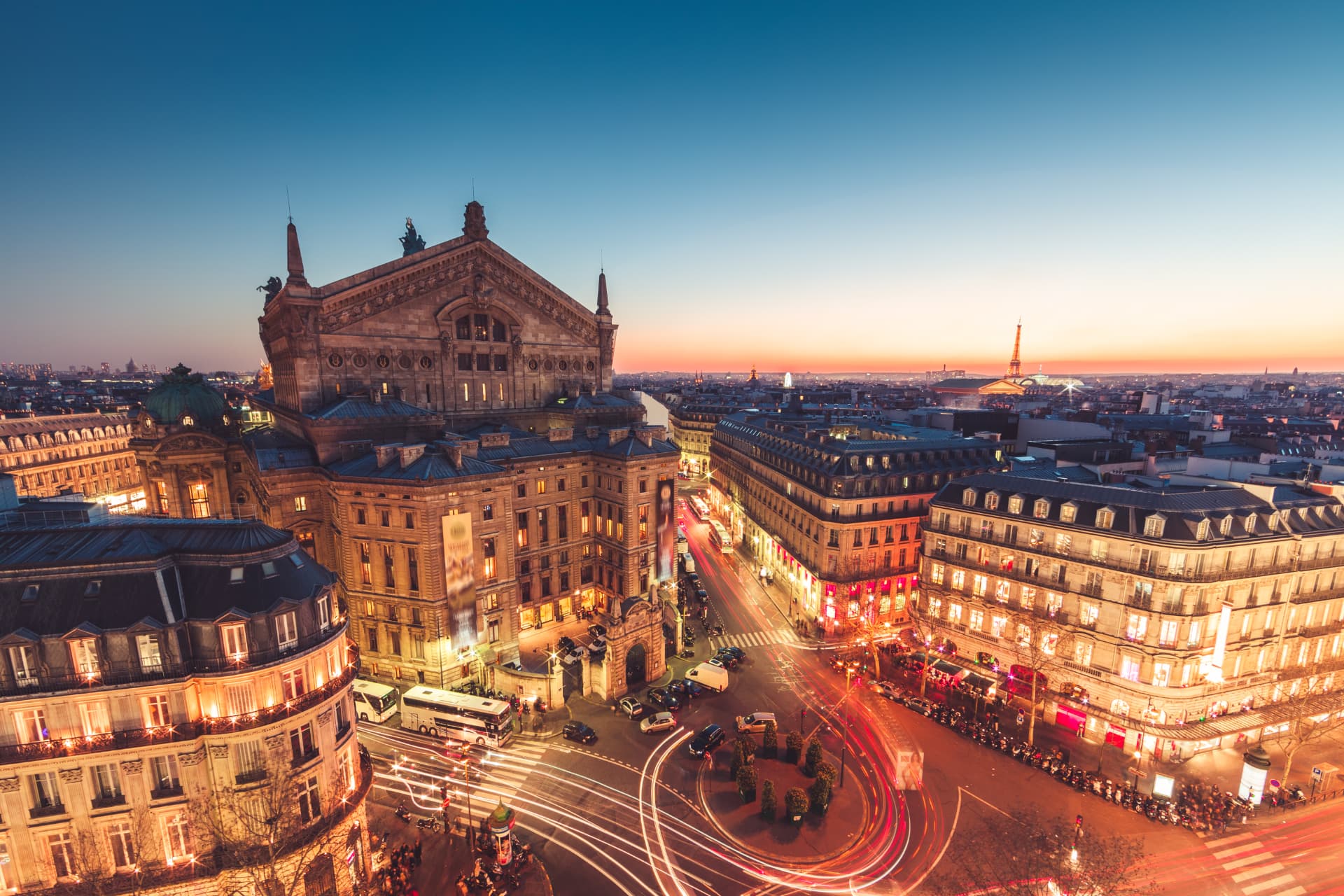 Aerial view of the Palais Garnier and the Opéra district of Paris at dusk with the Eiffel Tower on the horizon