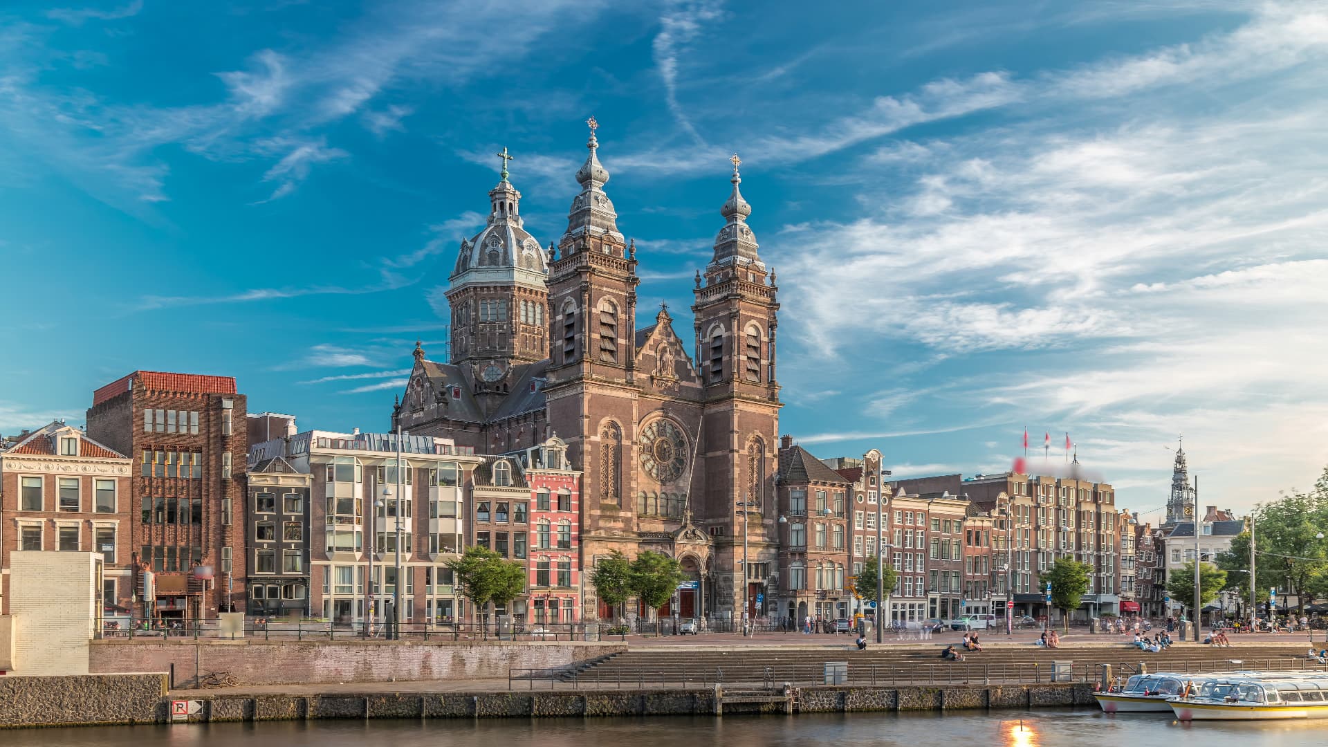 Basilica of St Nicholas rising over canal houses opposite Amsterdam Centraal Station