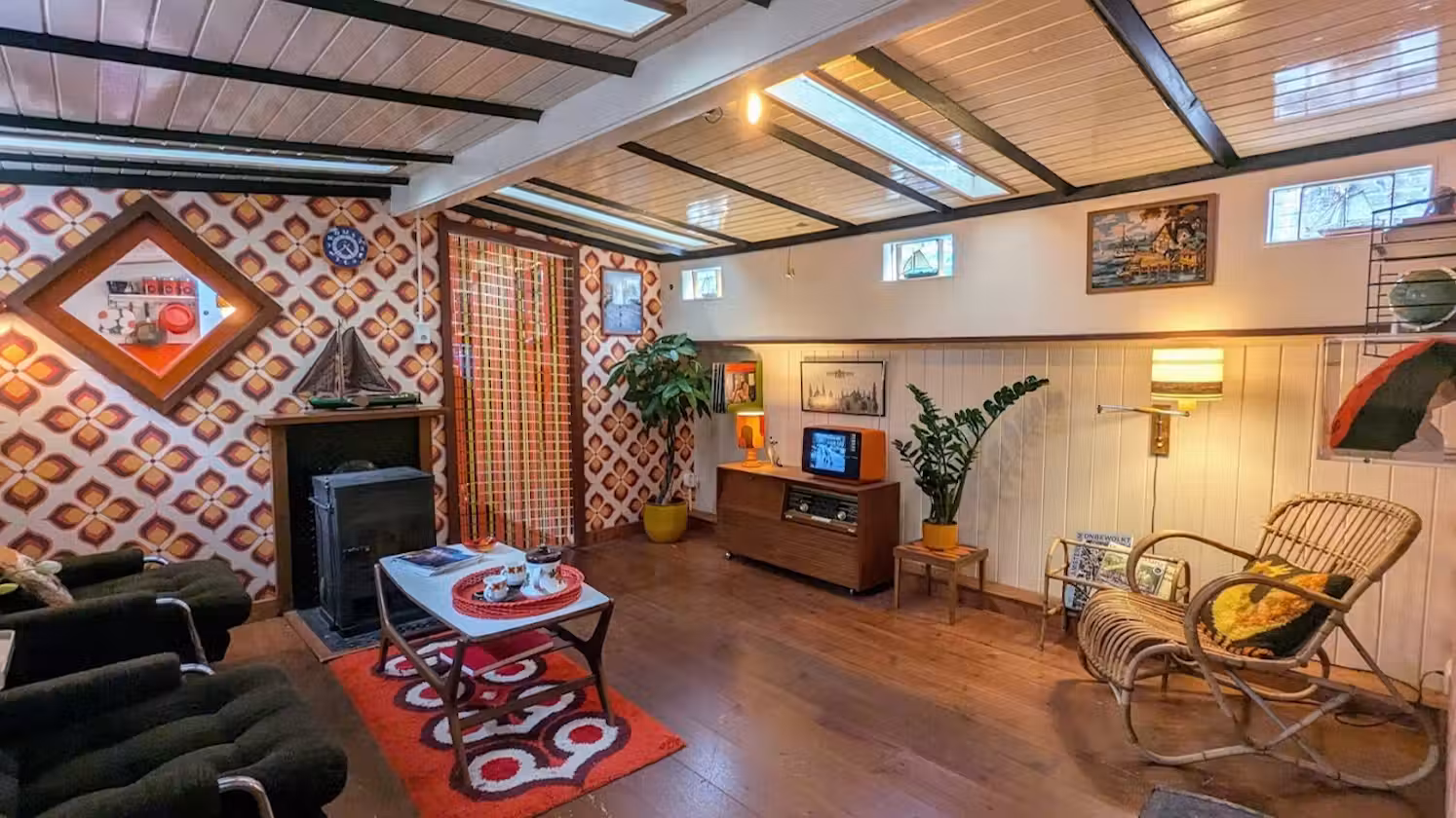 The wood-panelled living room inside the Houseboat Museum in Amsterdam with period furniture and skylights