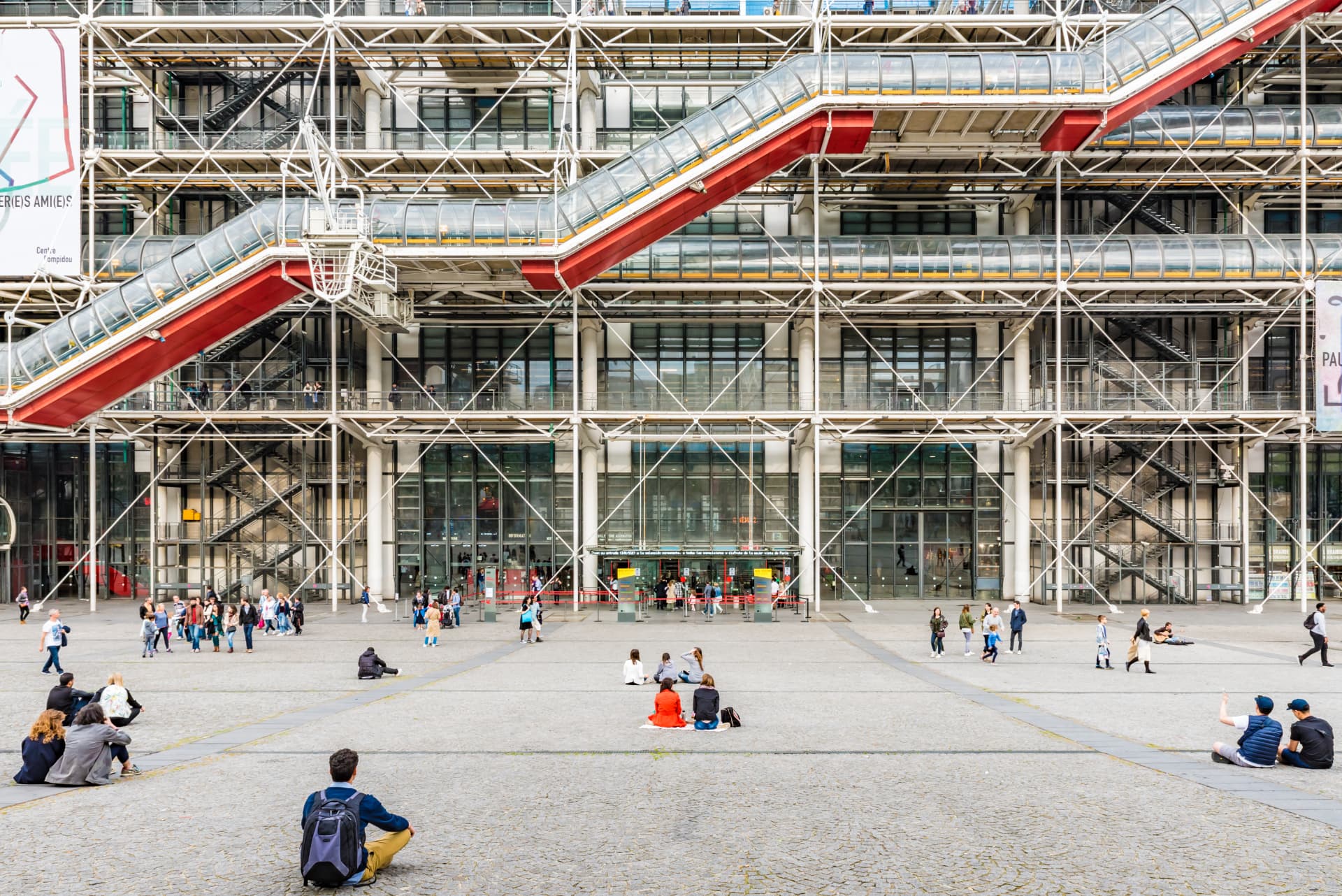 People sitting on the sloping cobbled piazza in front of the Centre Pompidou in Paris