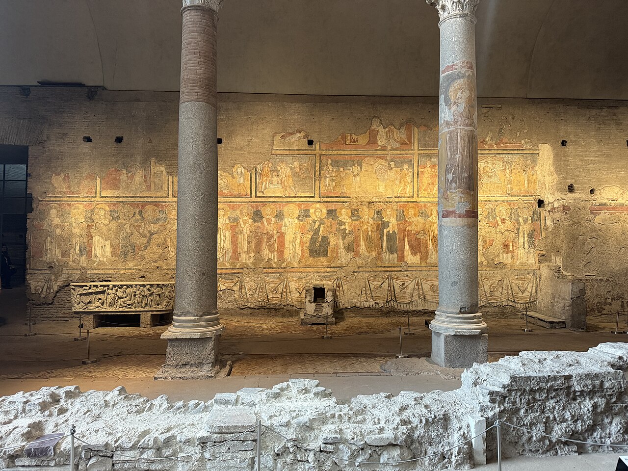 Frescoed wall with a row of saints and granite columns inside Santa Maria Antiqua