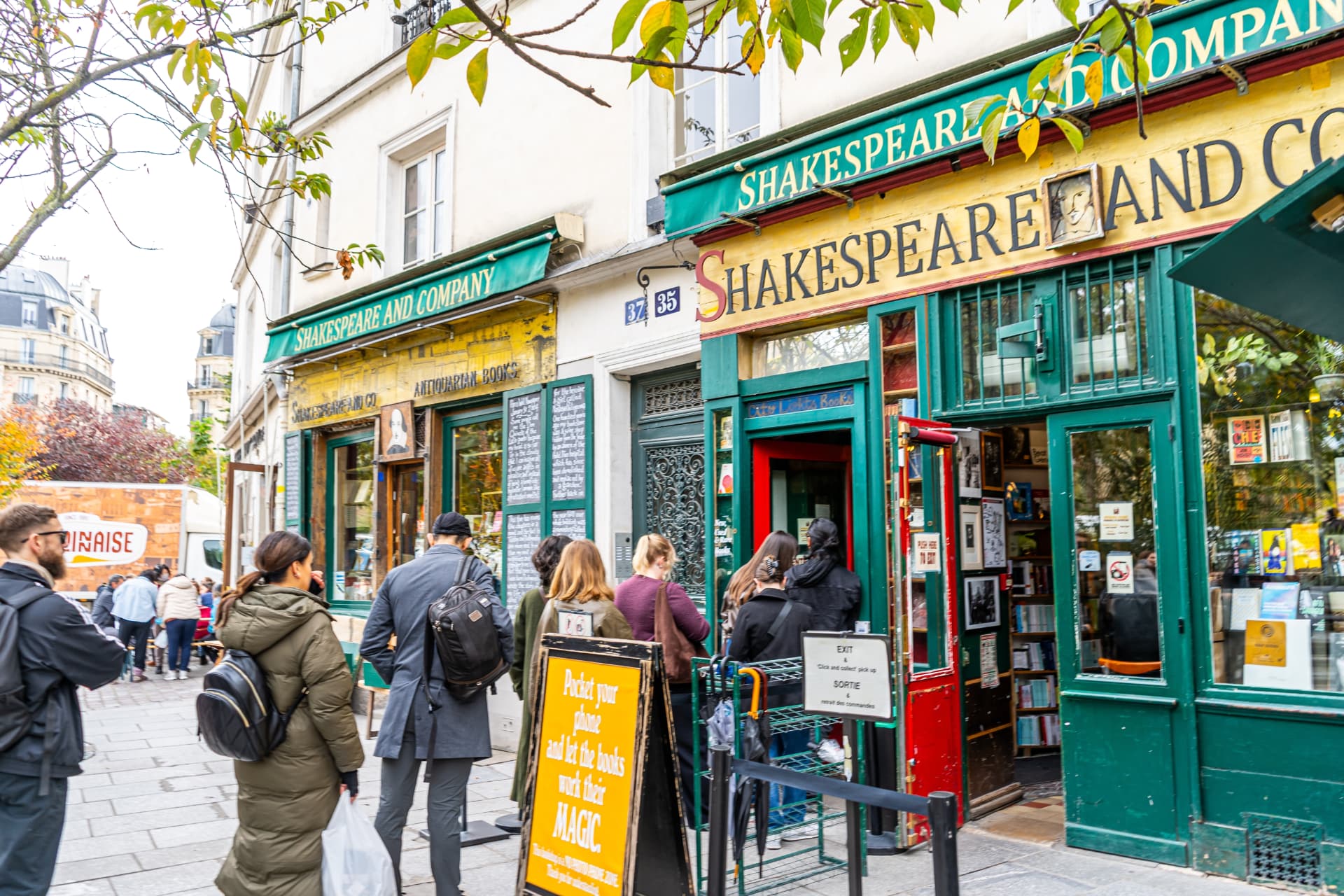 Visitors queuing outside Shakespeare and Company bookstore on a Paris street