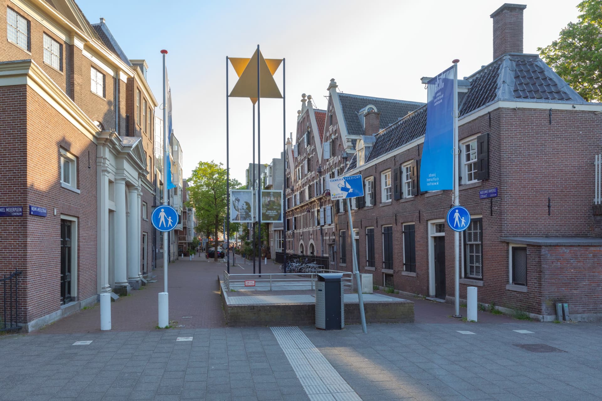 Jonas Daniel Meijerplein in Amsterdam with the yellow star monument, Jewish Cultural Quarter banners and historic brick buildings