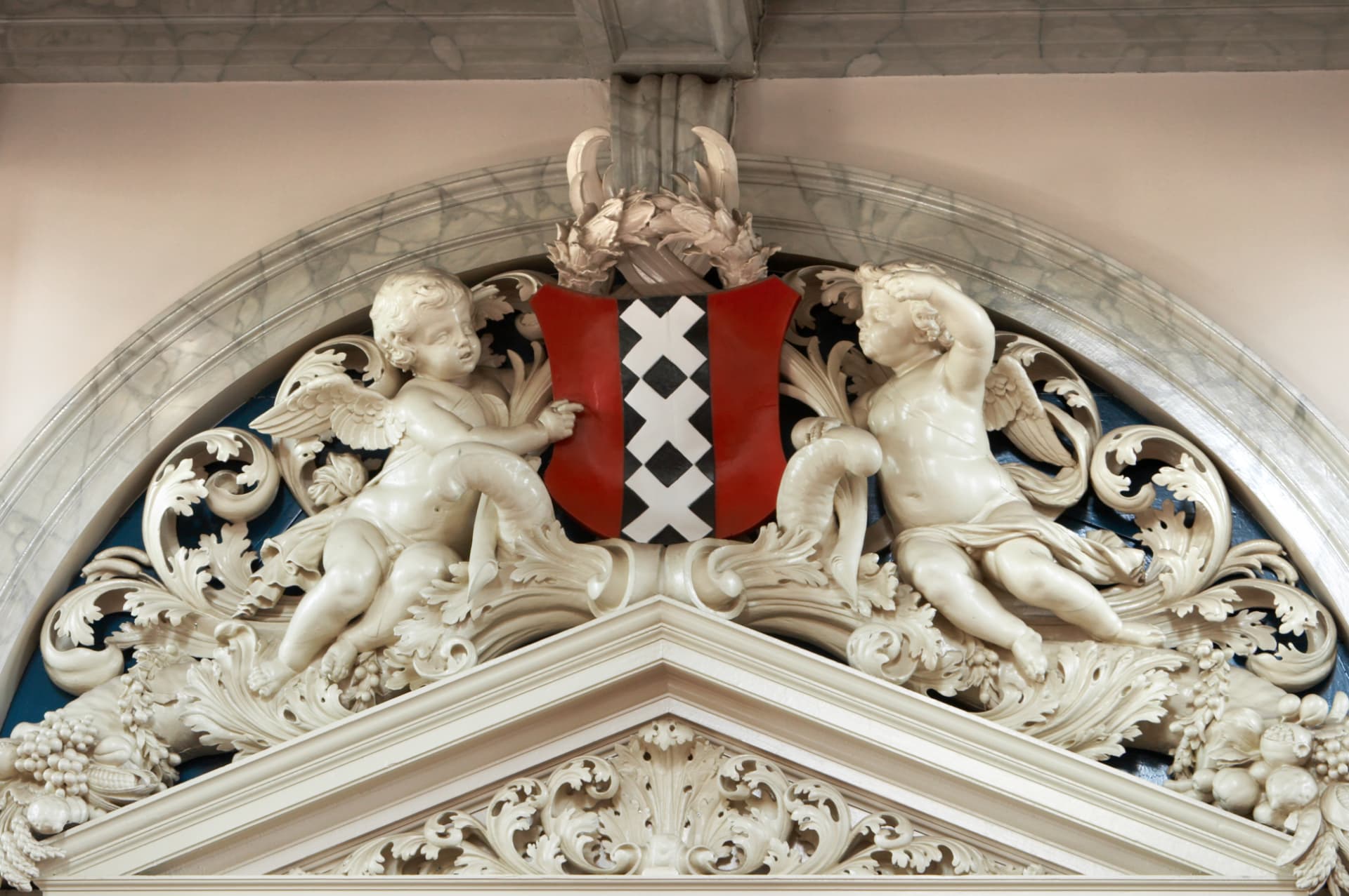 Stone carving of cherubs holding the coat of arms of Amsterdam inside the Westerkerk