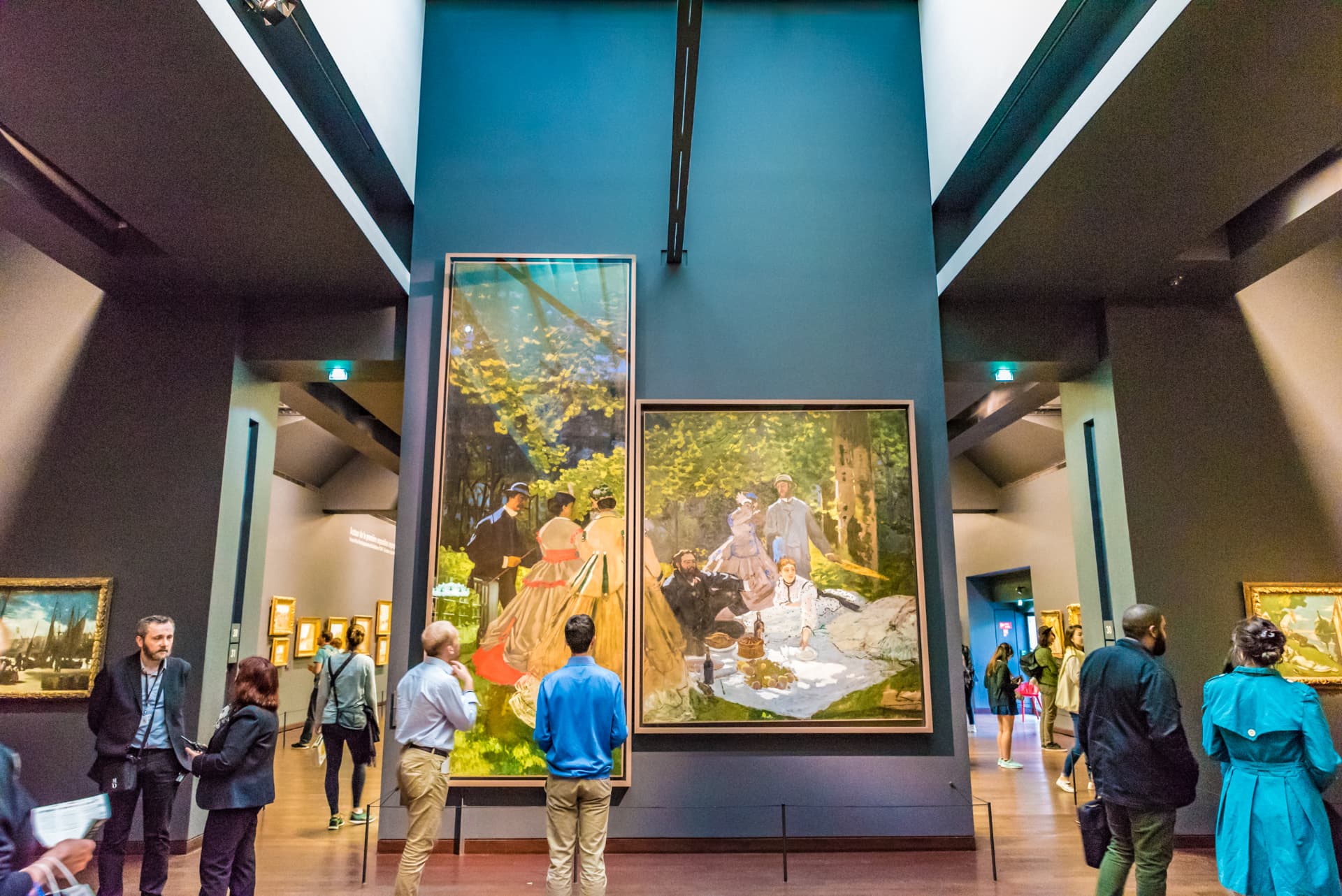 Visitors in front of large Impressionist paintings in the Musée d'Orsay galleries