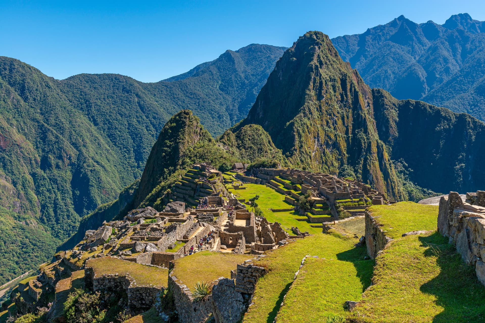 The classic view over Machu Picchu's stone ruins and green terraces with Huayna Picchu rising behind