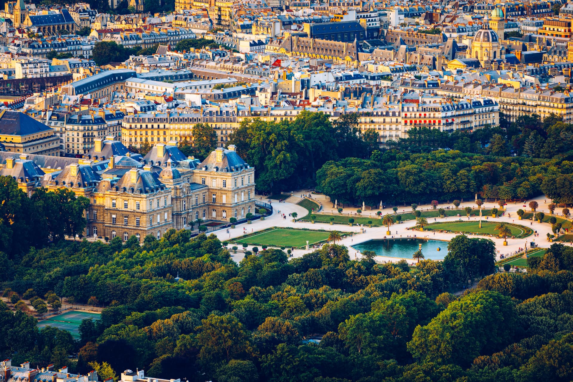 Aerial view of the Luxembourg Palace and gardens surrounded by the rooftops of Paris