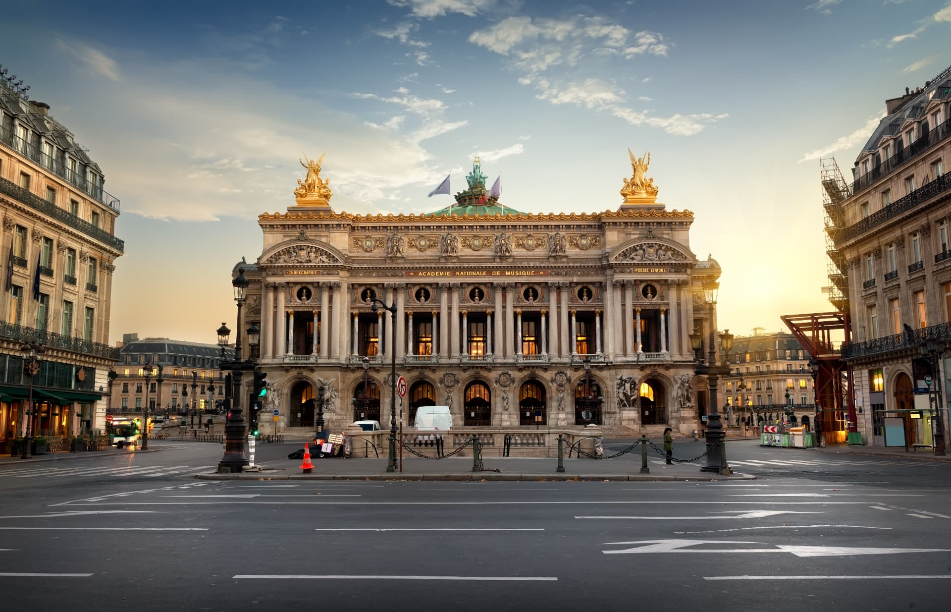 Facade of the Palais Garnier opera house in Paris with gilded statues at sunset