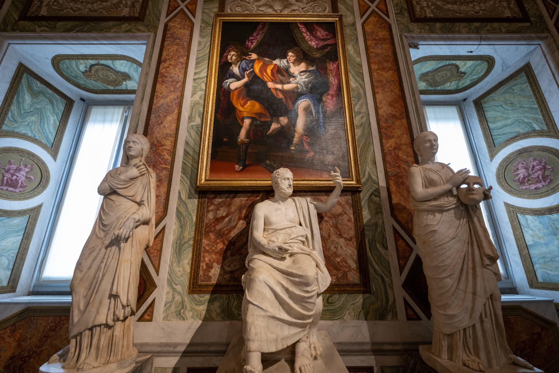 Classical sculptures and painting inside a richly decorated Roman gallery