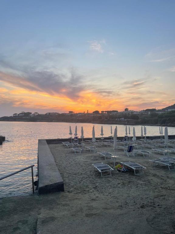 Beach loungers and umbrellas beside the sea at sunset in Santa Marinella