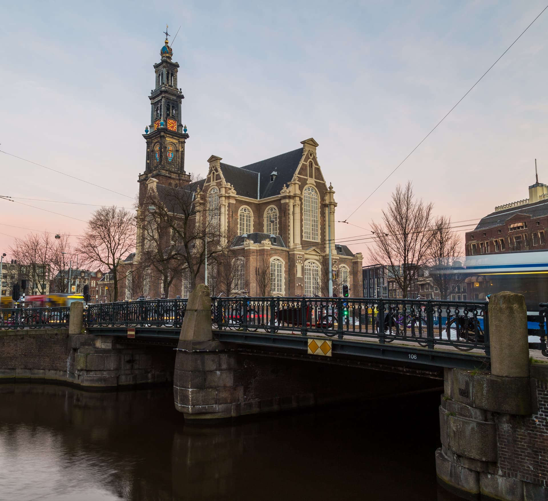 The Westerkerk and its Westertoren seen from a canal bridge at dusk in Amsterdam