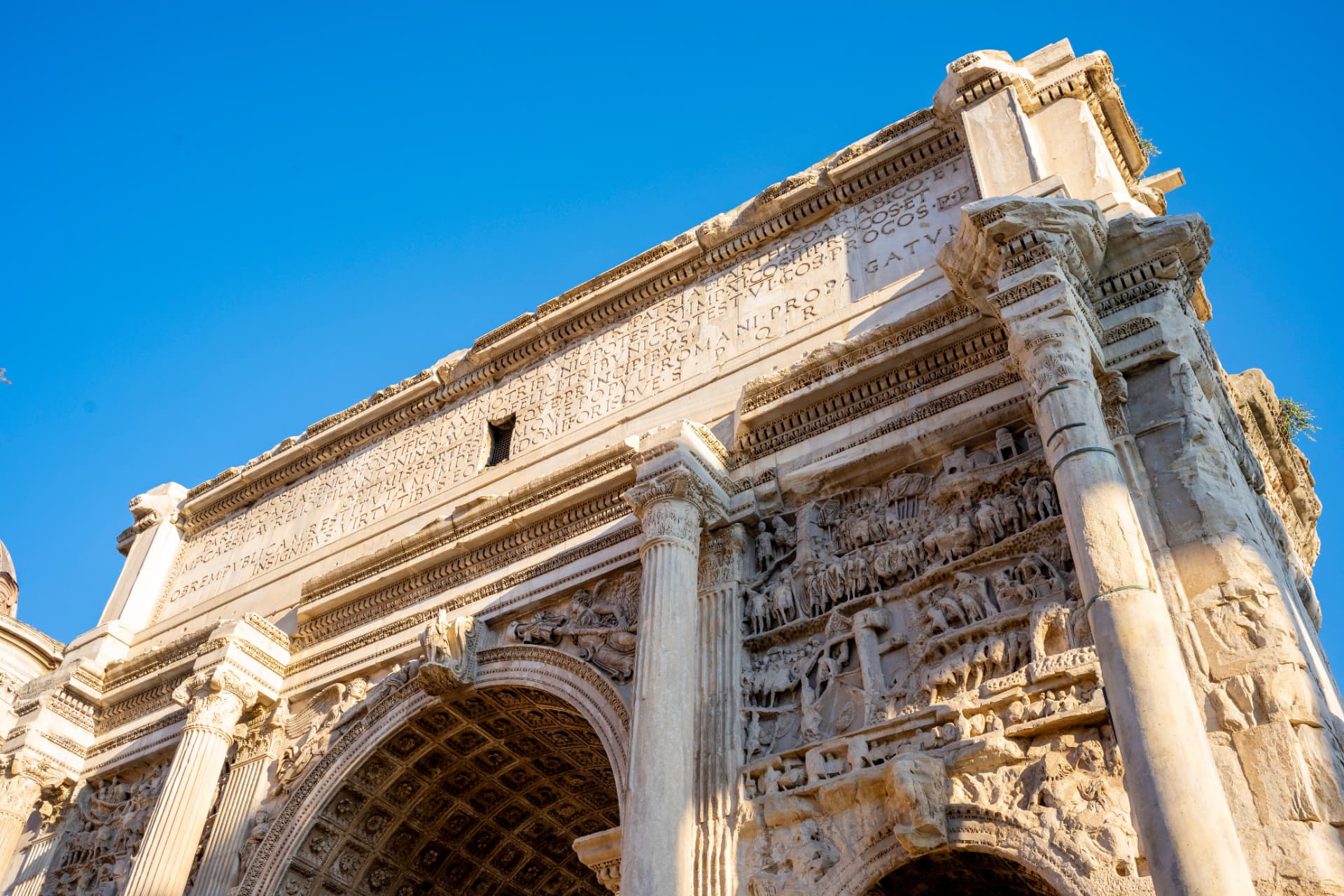 Close-up of the inscription and battle reliefs on the attic of the Arch of Septimius Severus
