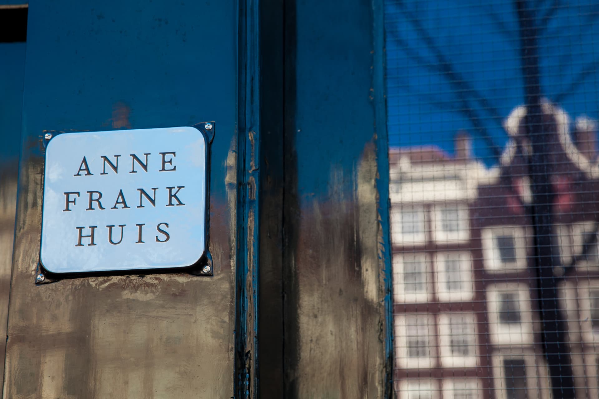 Close-up of the Anne Frank Huis sign on the green door of the museum