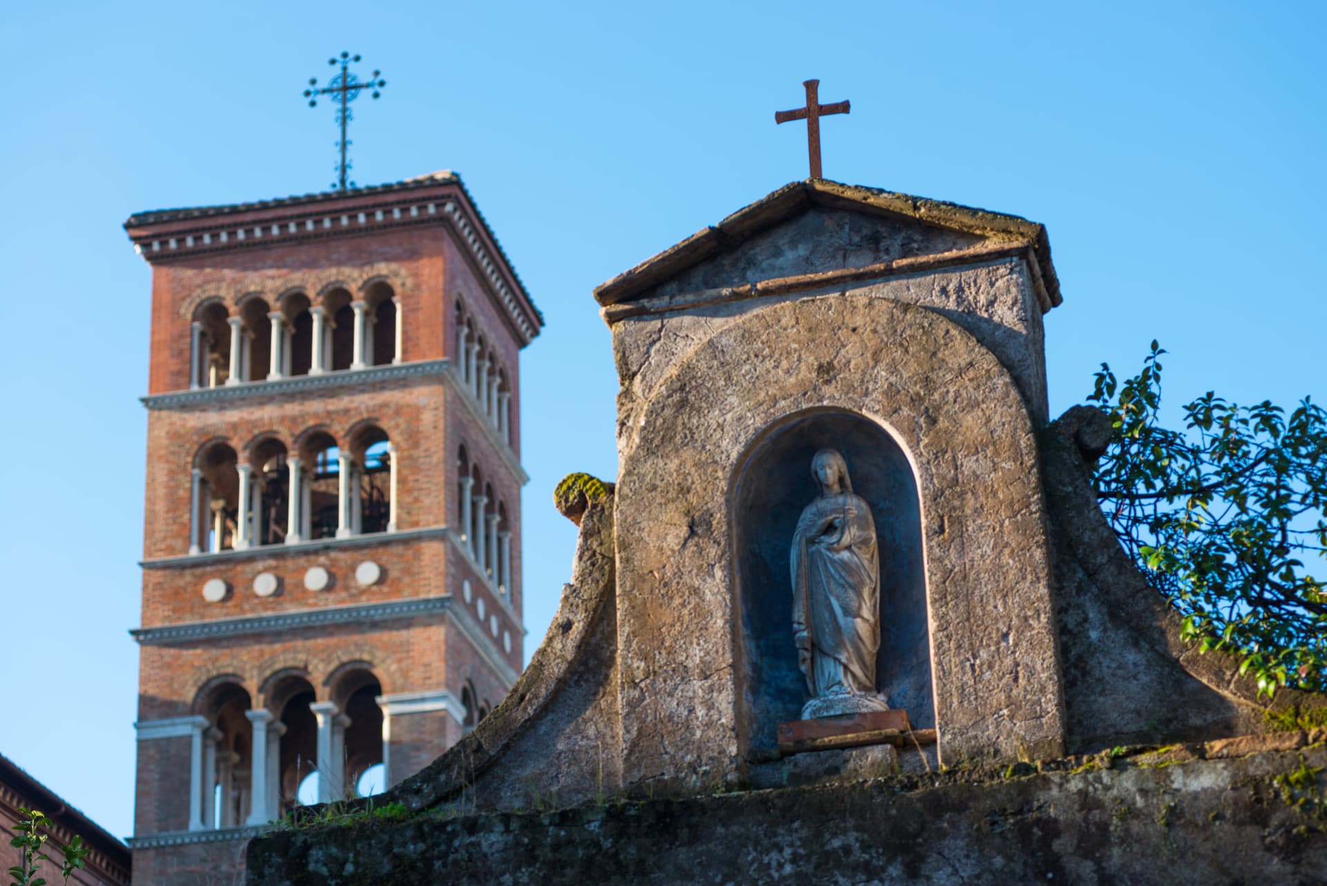 Santa Sabina’s medieval brick bell tower against a blue sky