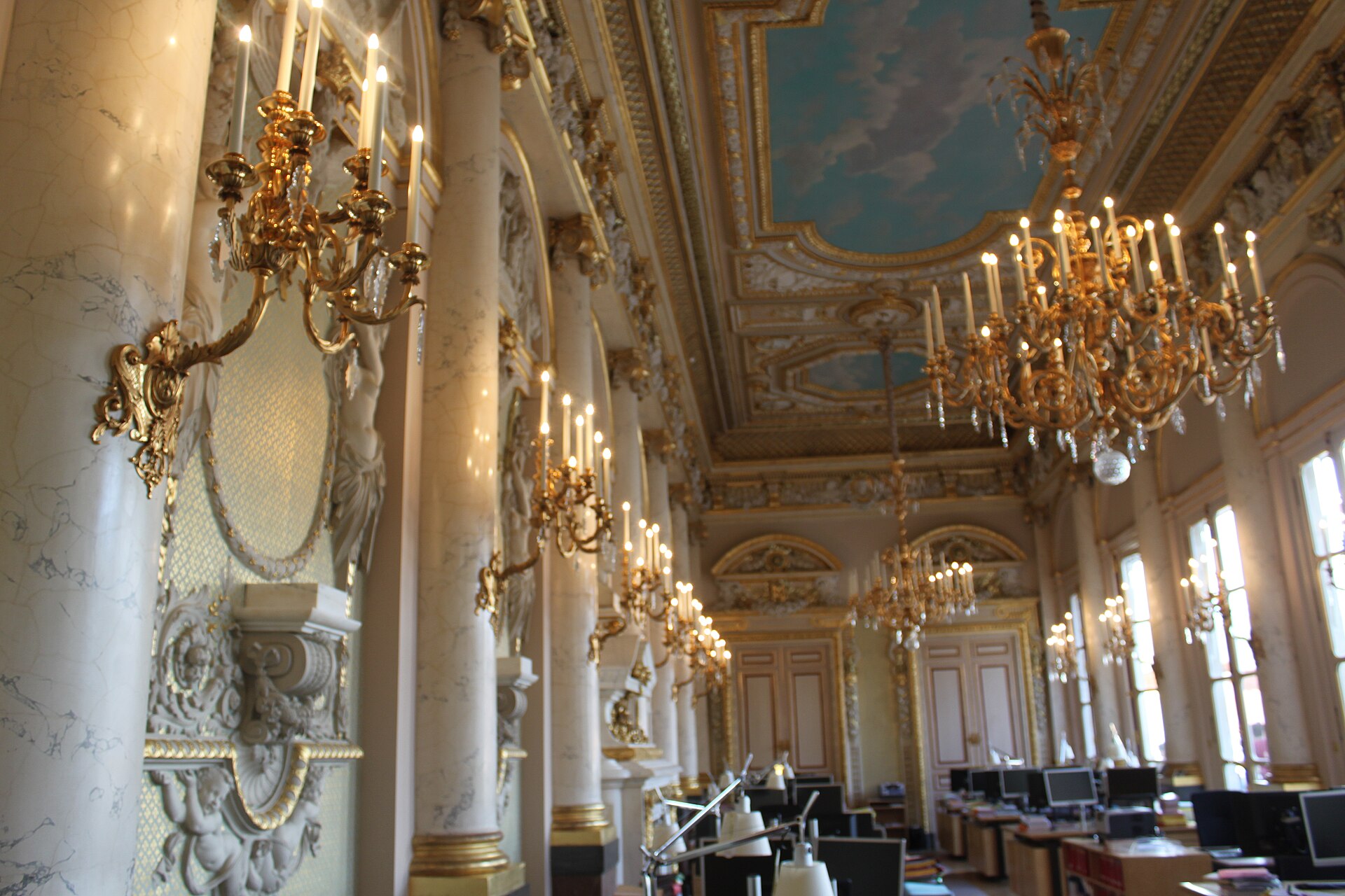 Gilded chandeliers and painted ceiling of the Salle Napoléon in the Conseil d'État at the Palais Royal