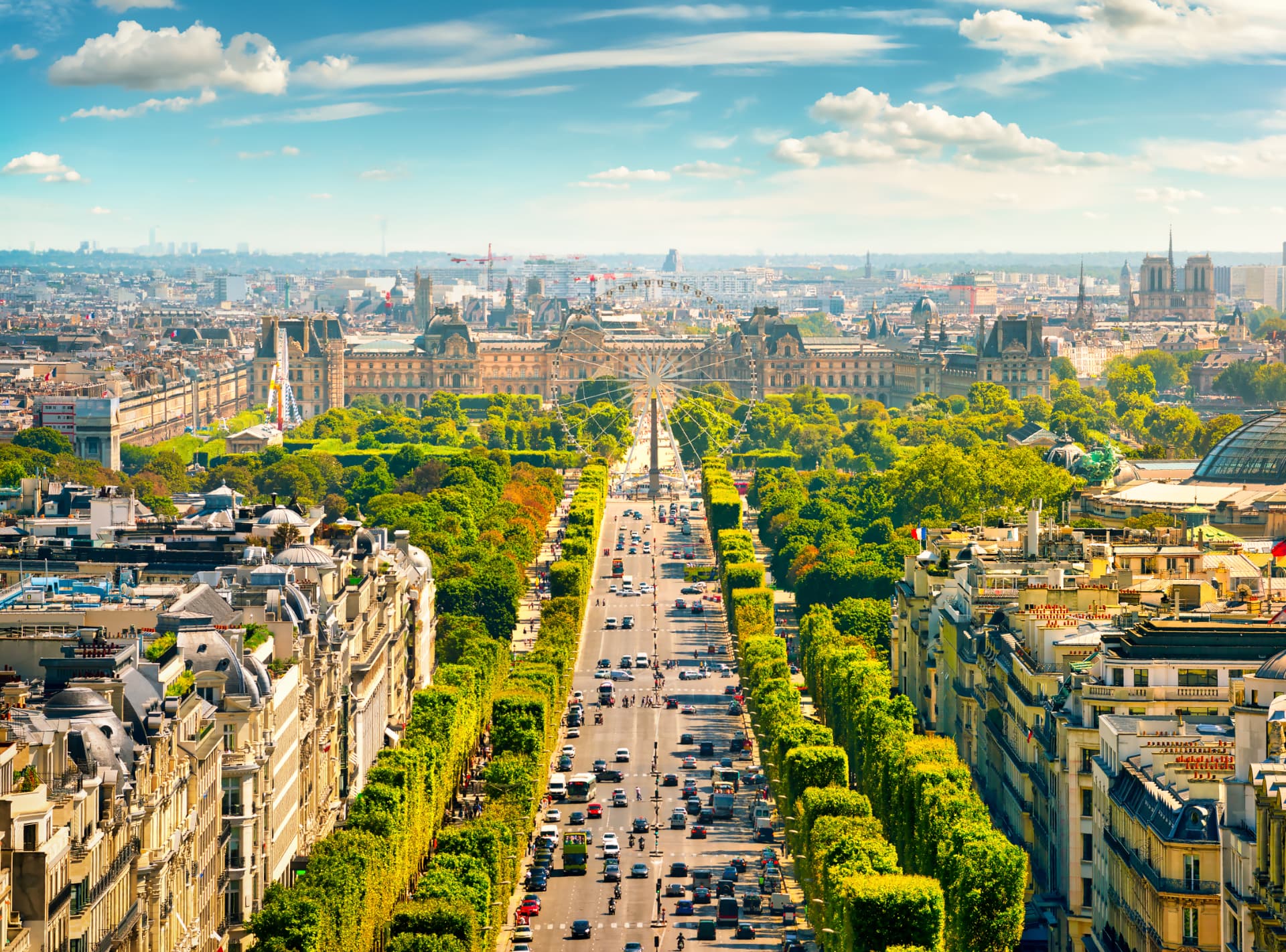 Elevated daytime view down the tree-lined Champs-Élysées toward Place de la Concorde and the Tuileries