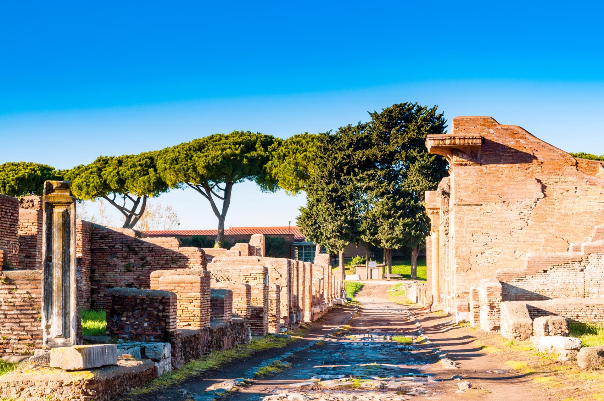 Ancient brick buildings and a paved Roman street at Ostia Antica