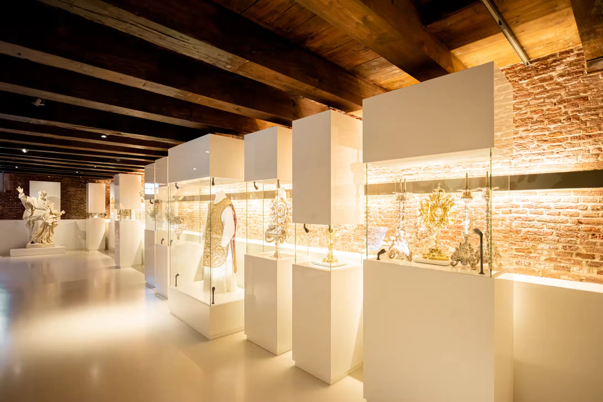 Display cases with liturgical silver, vestments and a statue inside Museum Ons' Lieve Heer op Solder