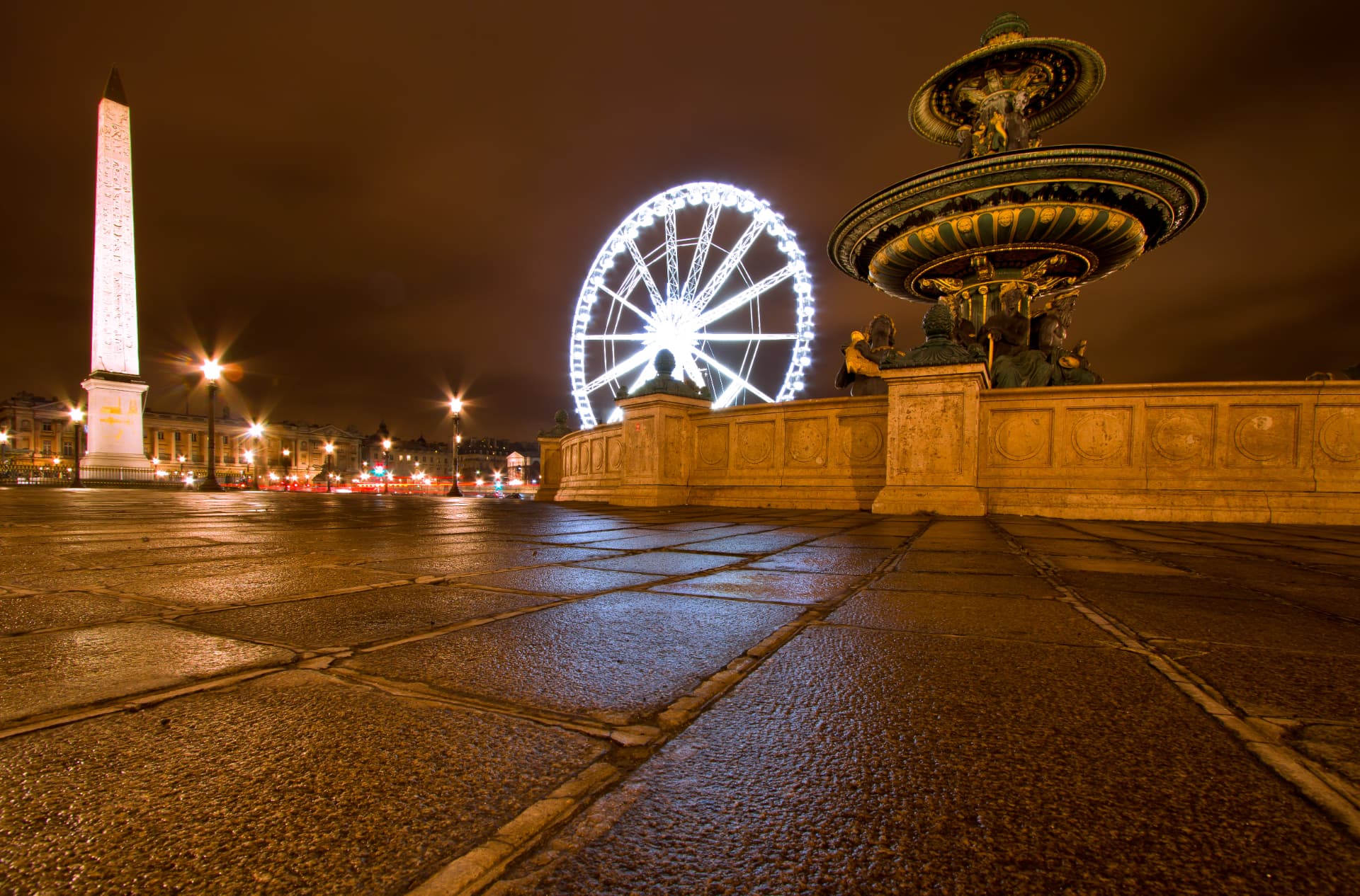 Place de la Concorde at night with the Luxor Obelisk, fountain and illuminated Ferris wheel