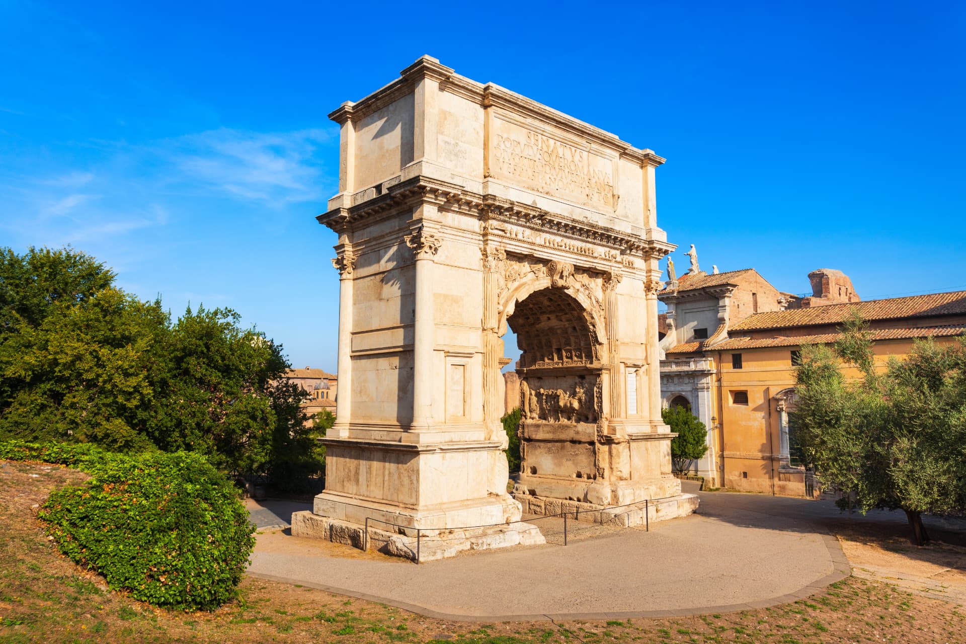Arch of Titus on the Via Sacra in Rome — the 1st-century triumphal arch honouring the deified Emperor Titus, with the dedicatory inscription on the attic and the Colosseum behind