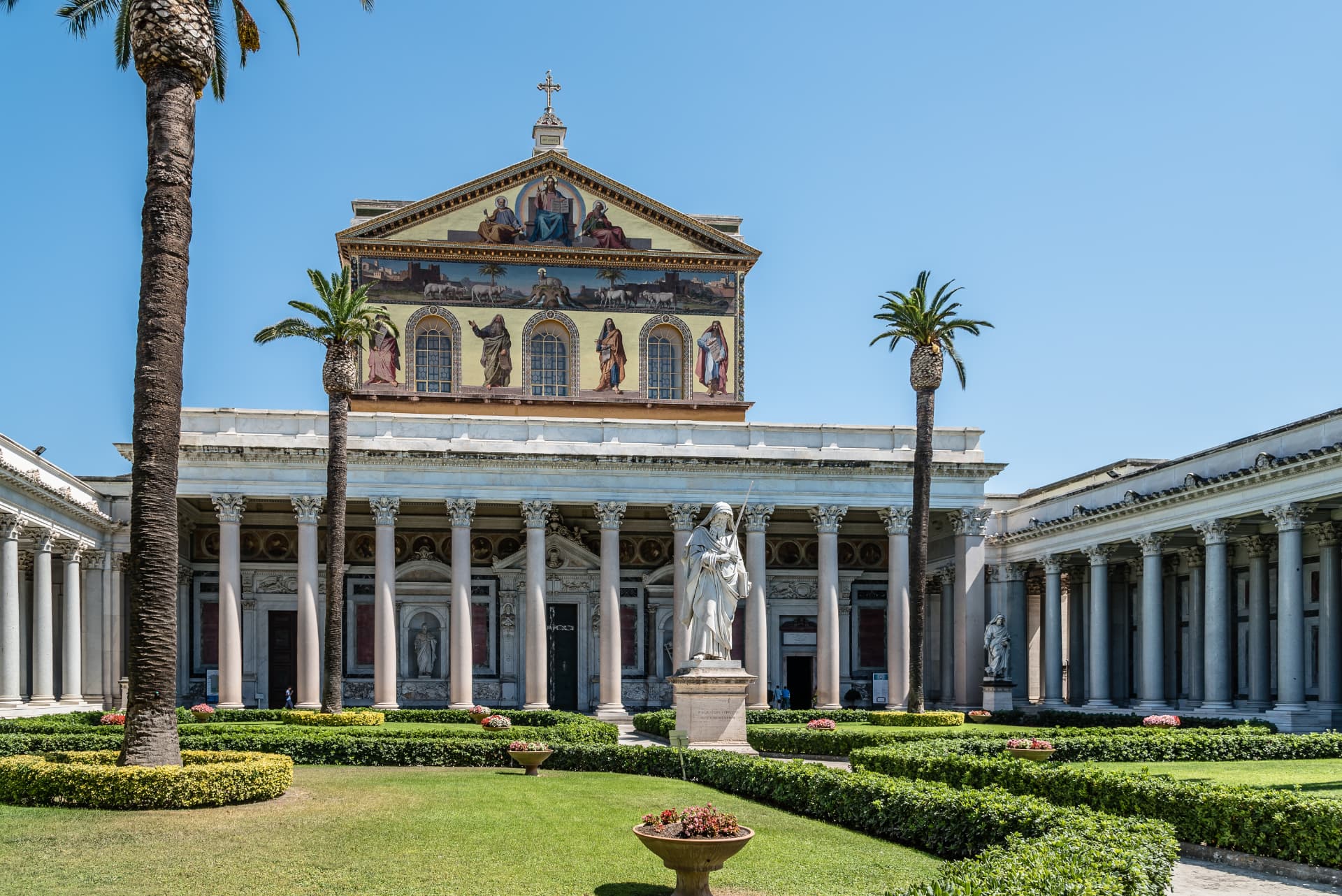 Basilica di San Paolo fuori le Mura facade with golden mosaics and palm trees