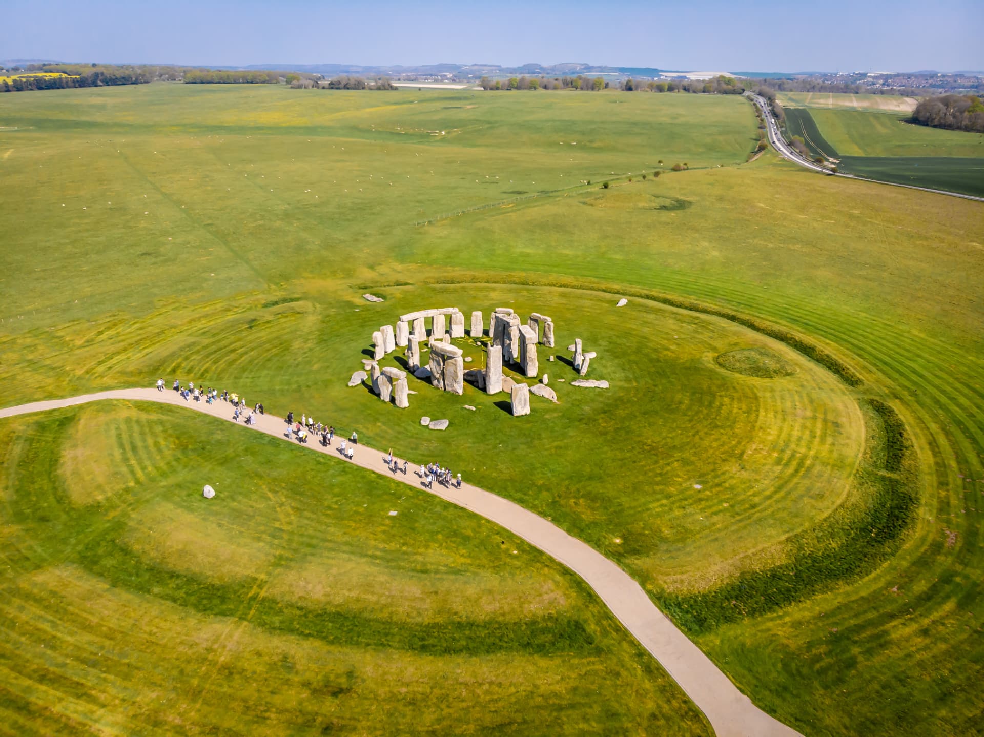 Aerial view of Stonehenge showing the circular monument, the visitor path and the surrounding green fields of Salisbury Plain